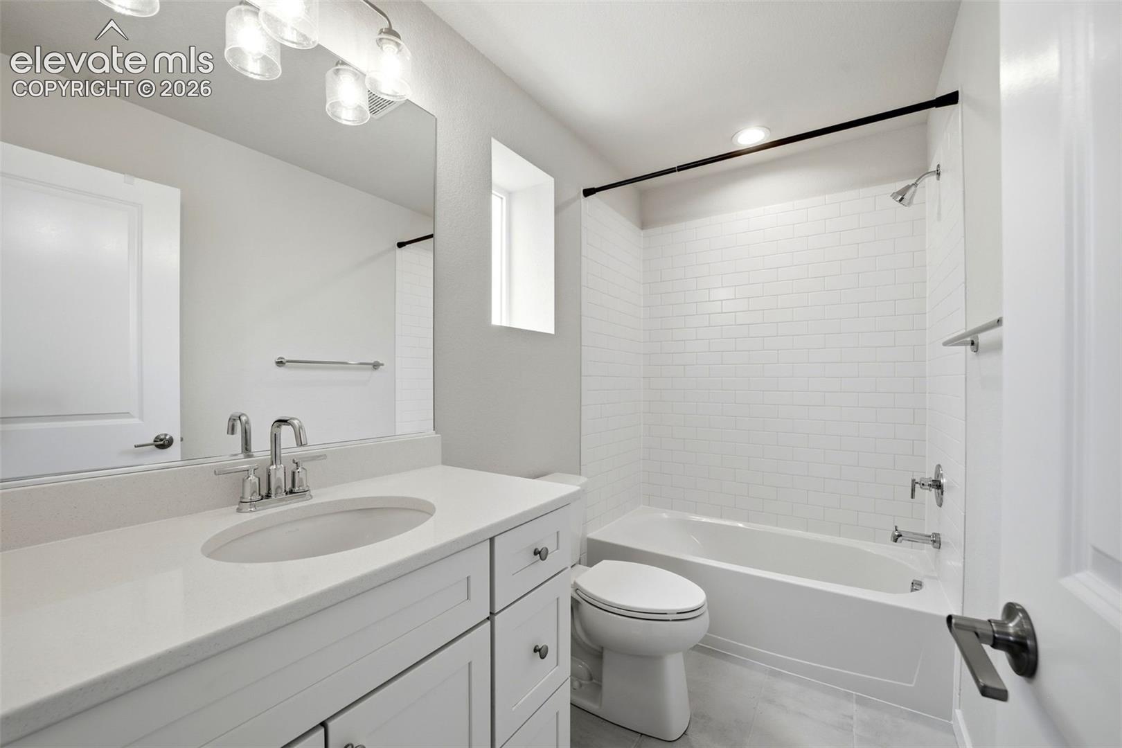 Bathroom 2 - White vanity with integrated sink, polished chrome faucet, and quartz-finish countertop