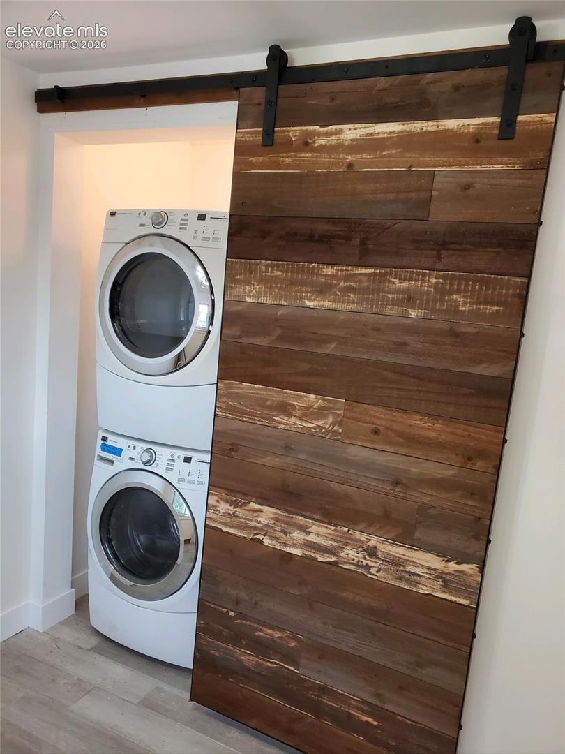 Wood-finish barn door with exposed black metal hardware