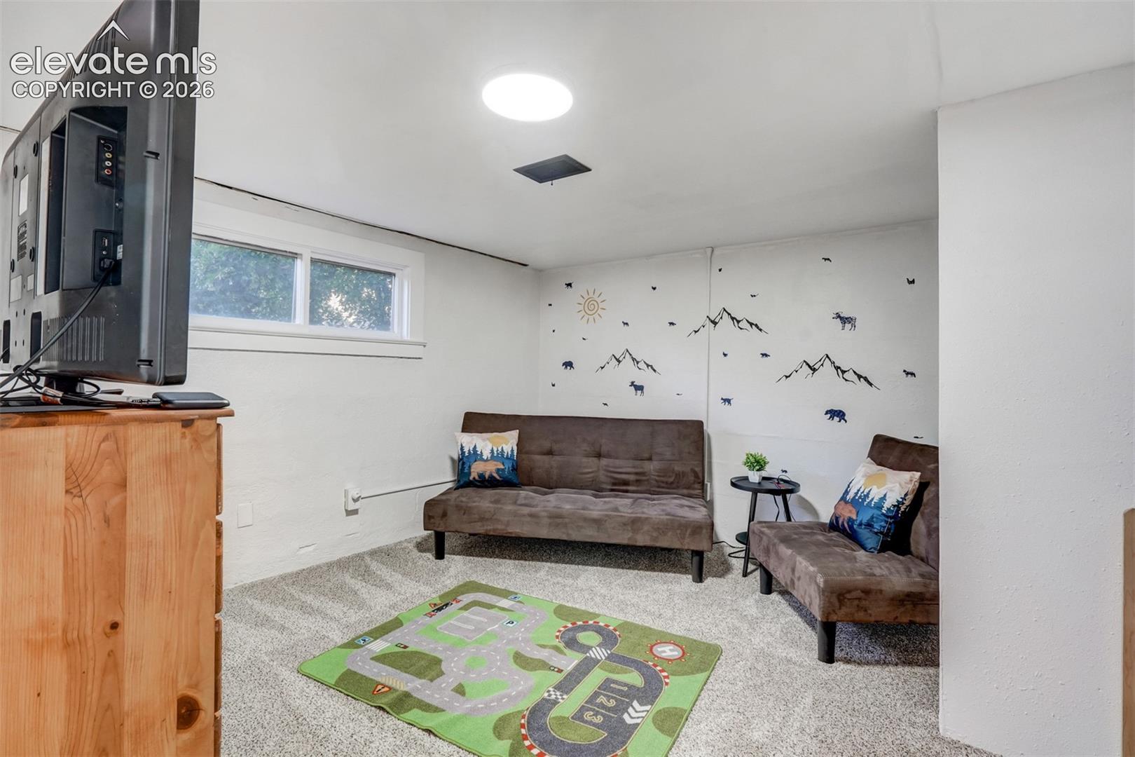 Recessed lighting, wall-to-wall carpeting, and a window for natural light