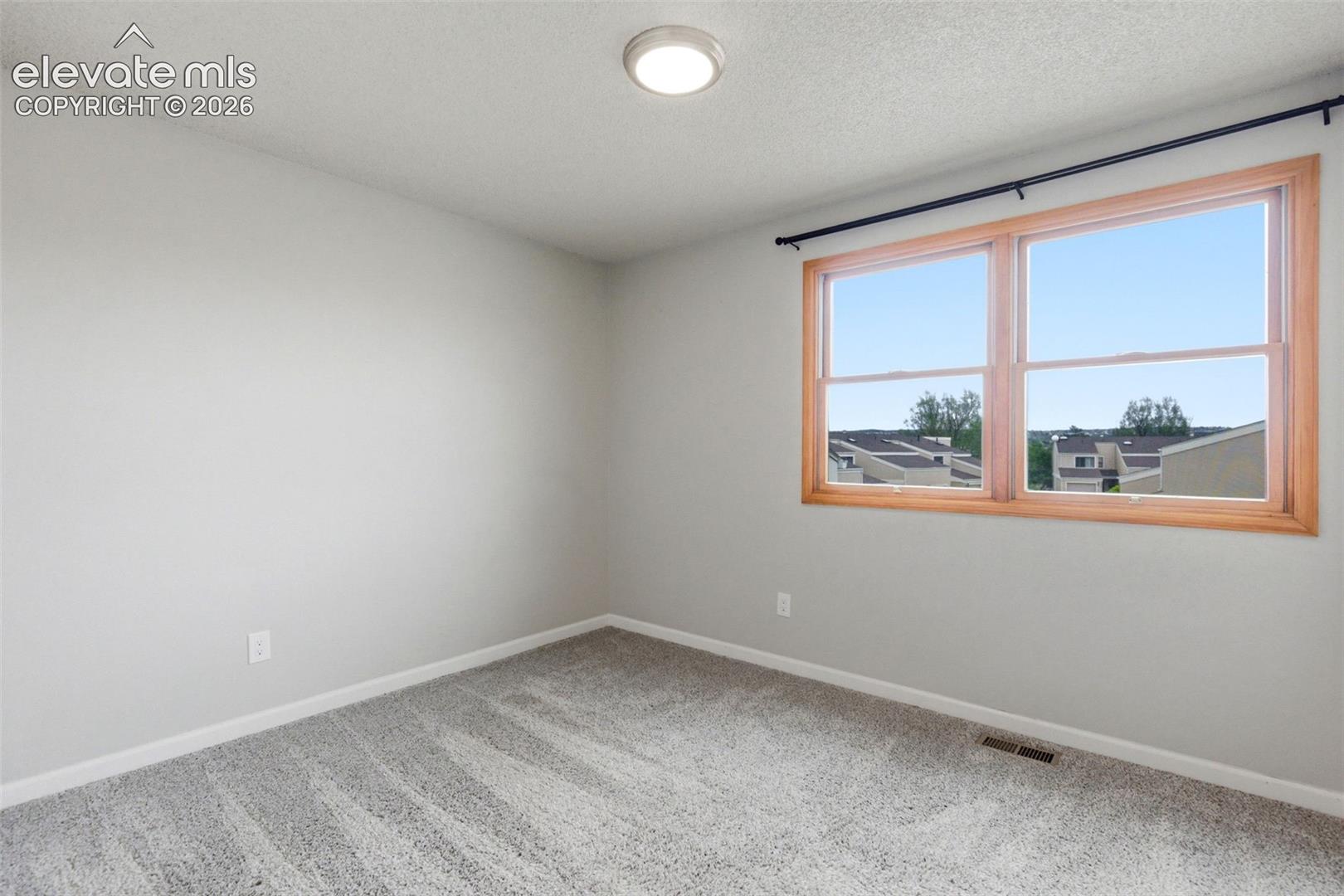 Spacious room with a double window featuring natural wood-finish trim