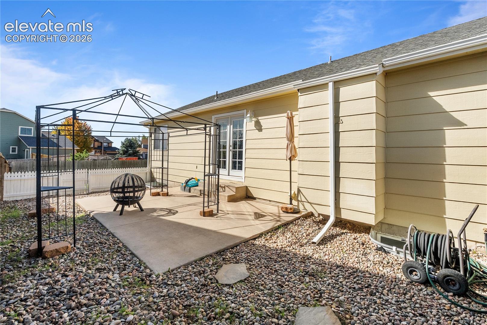 Rear exterior with light-colored siding and a concrete patio