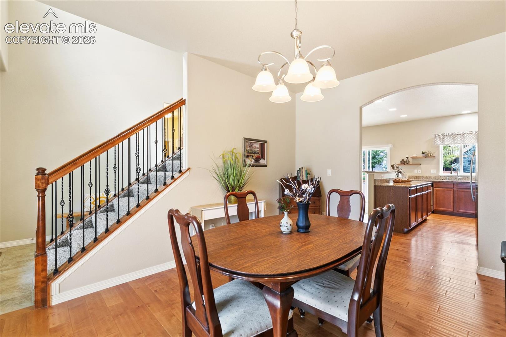 Dining room with wood floors and chandelier, walk-through to the kitchen
