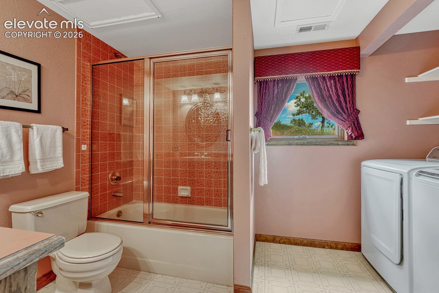 Main Level Bathroom with laundry area including the washer and dryer that stay.