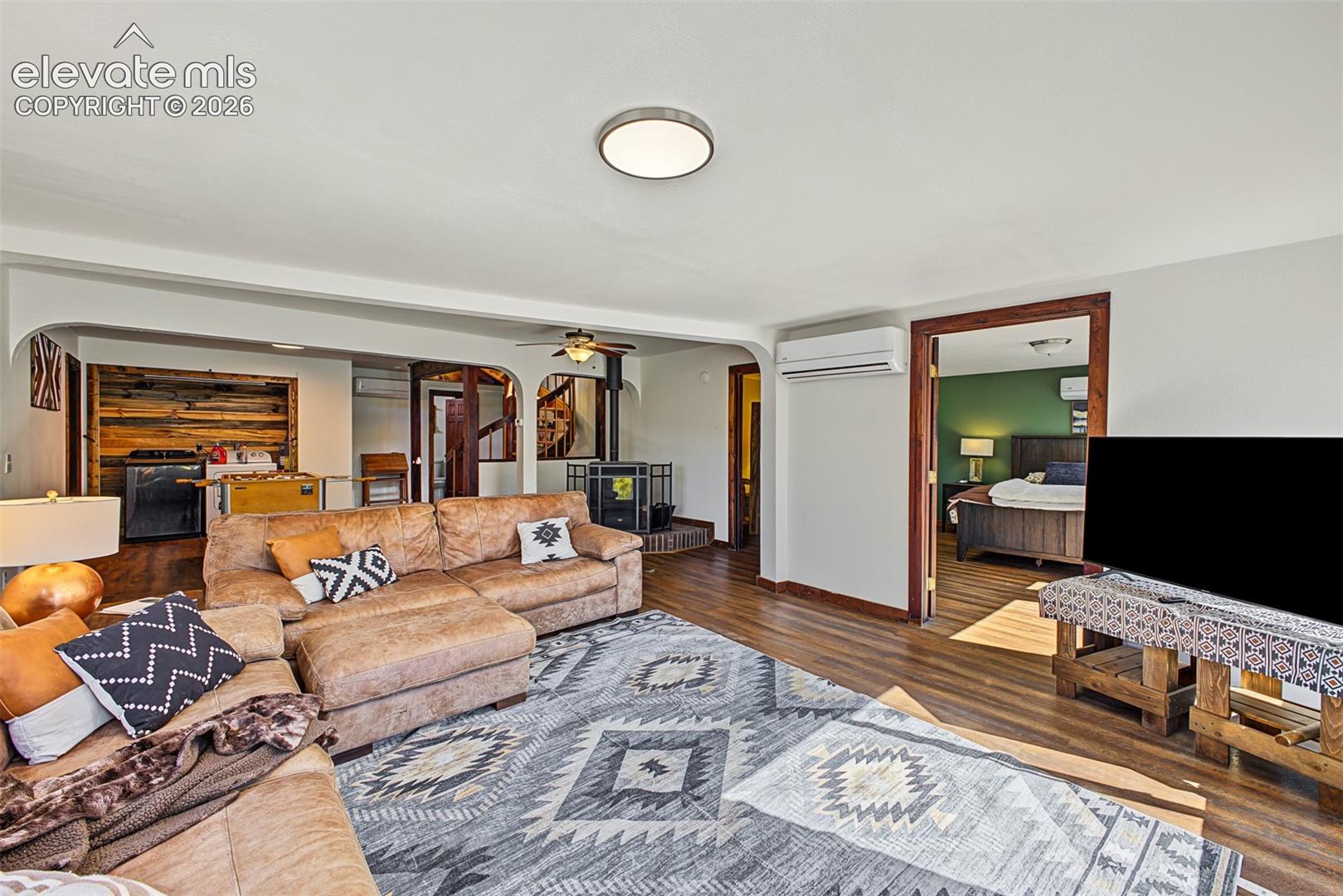 Wood-finish flooring throughout, featuring a built-in wood-burning stove and a ceiling fan
