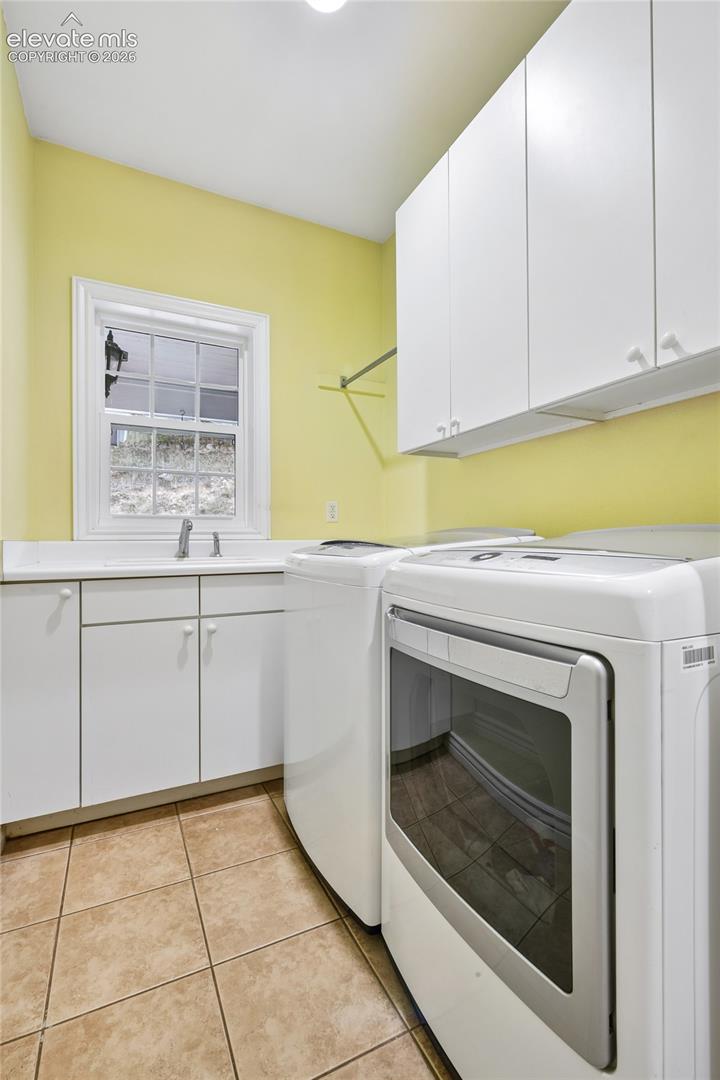 Laundry off of mudroom with utility sink, built-ins and nature views