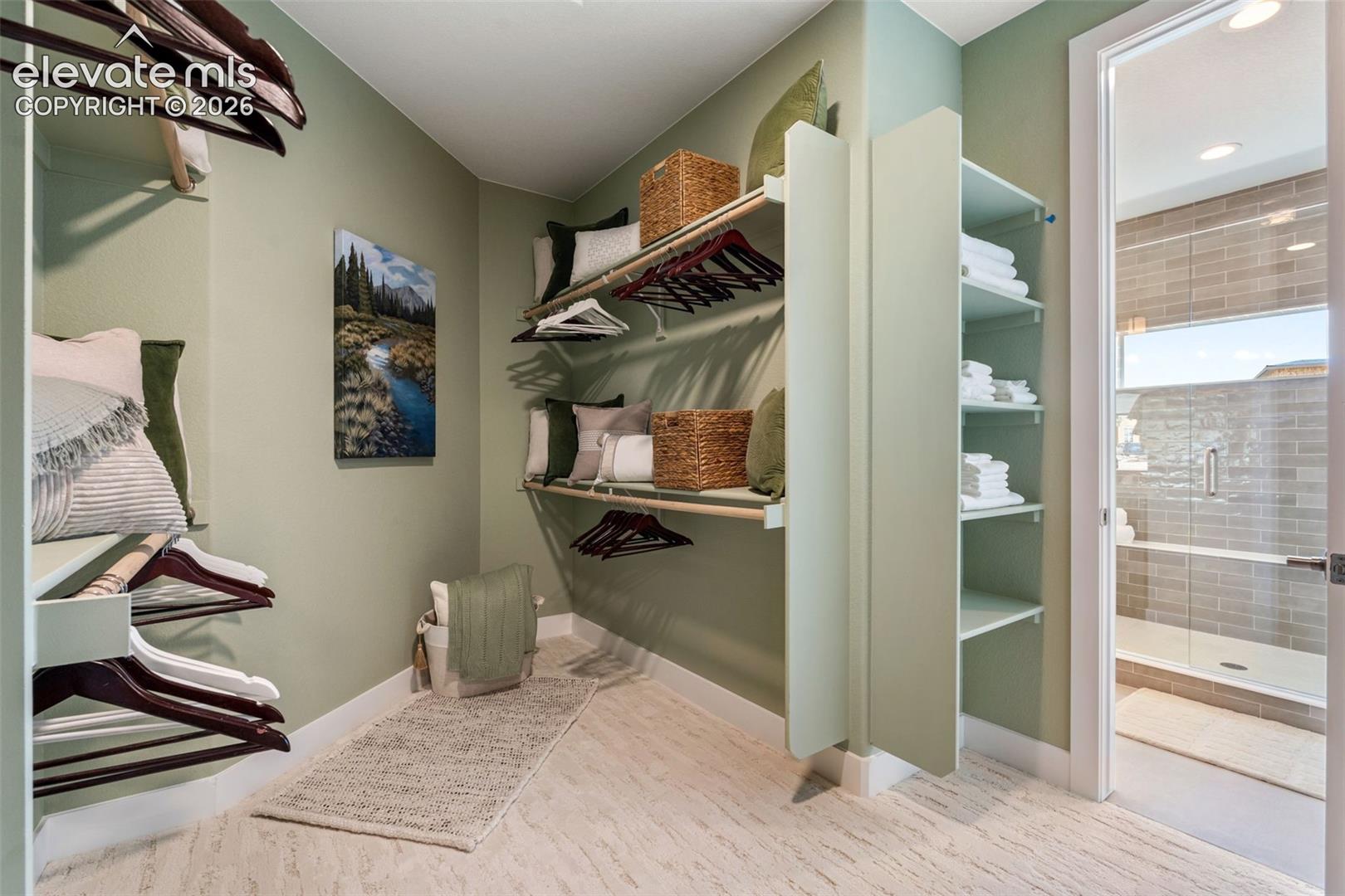 Walk-in closet featuring custom built-in shelving, tiered hanging rods, and patterned resilient flooring