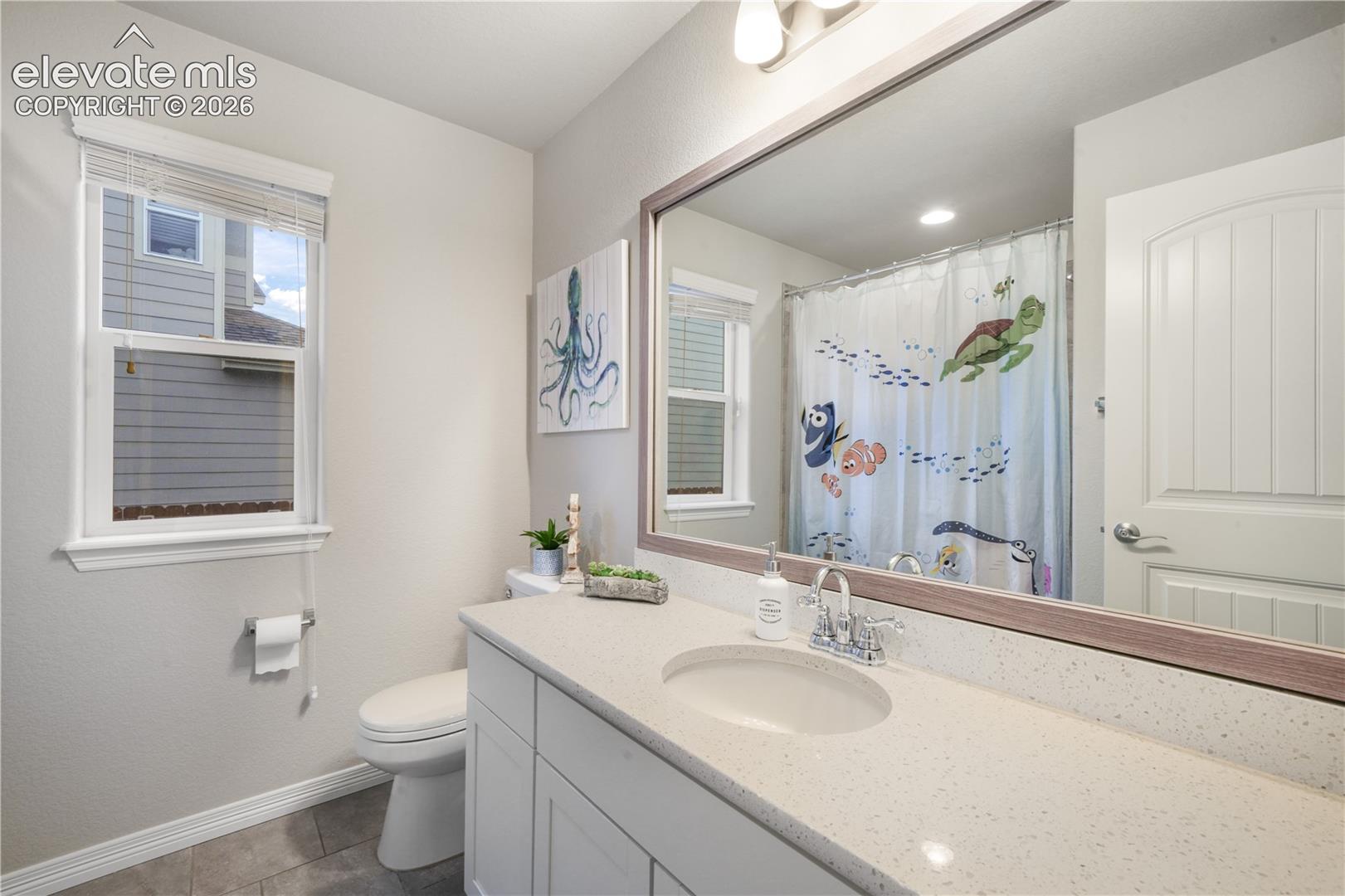 White vanity with integrated sink, speckled countertop, and chrome faucet
