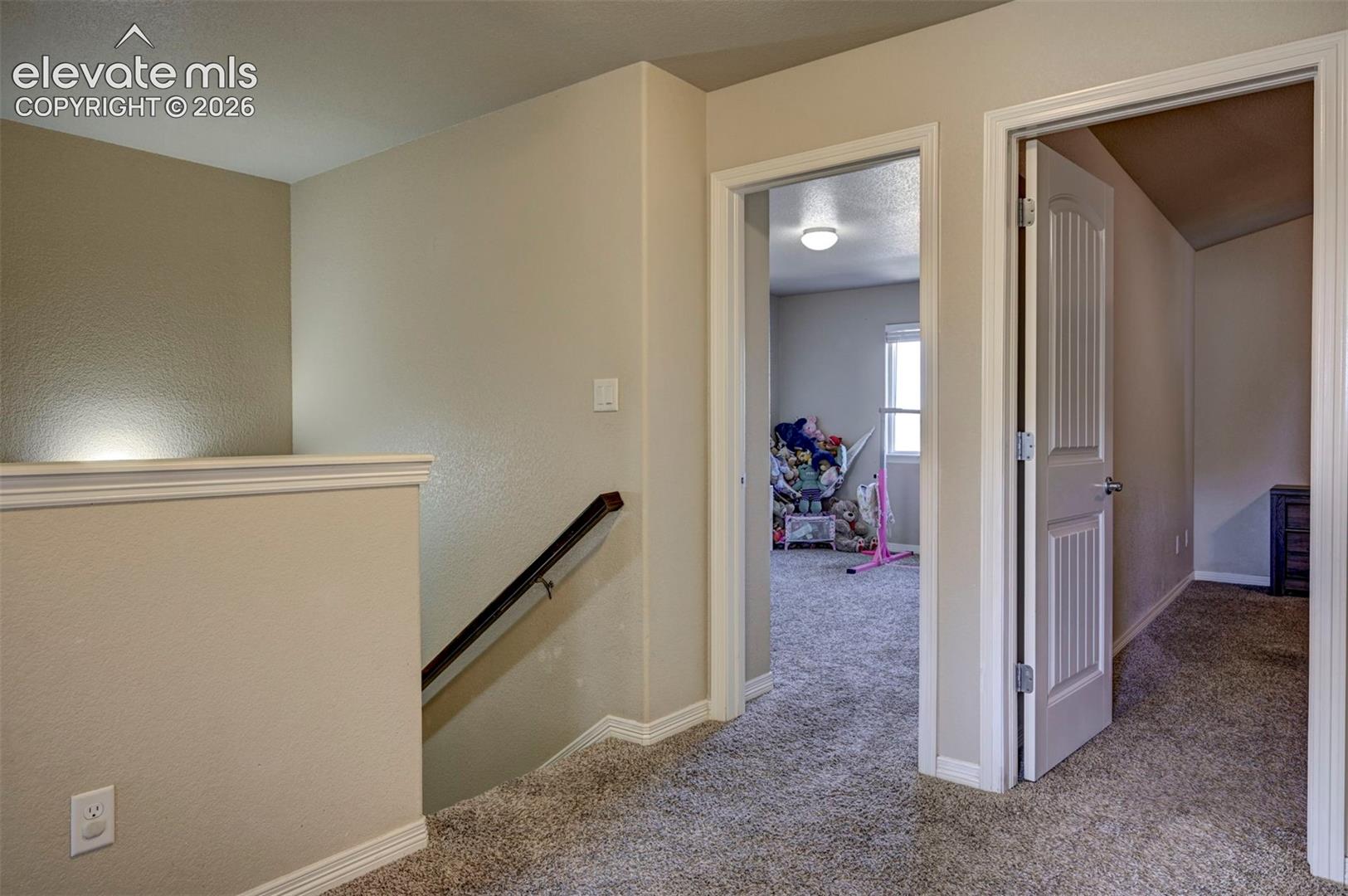 Neutral wall color throughout, white trim, carpeted flooring, and white interior doors