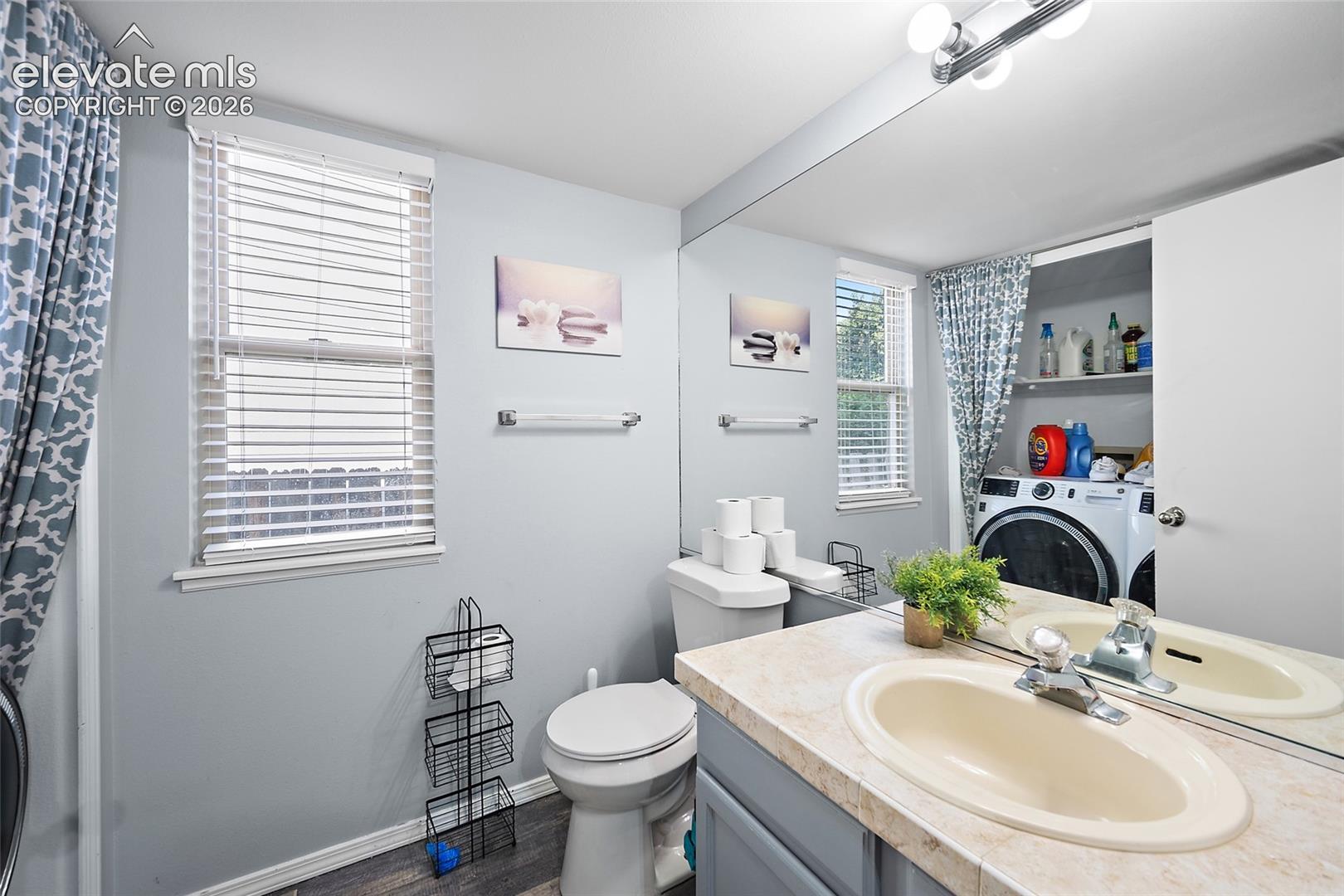 Vanity with an integrated sink, full-width mirror, and overhead lighting