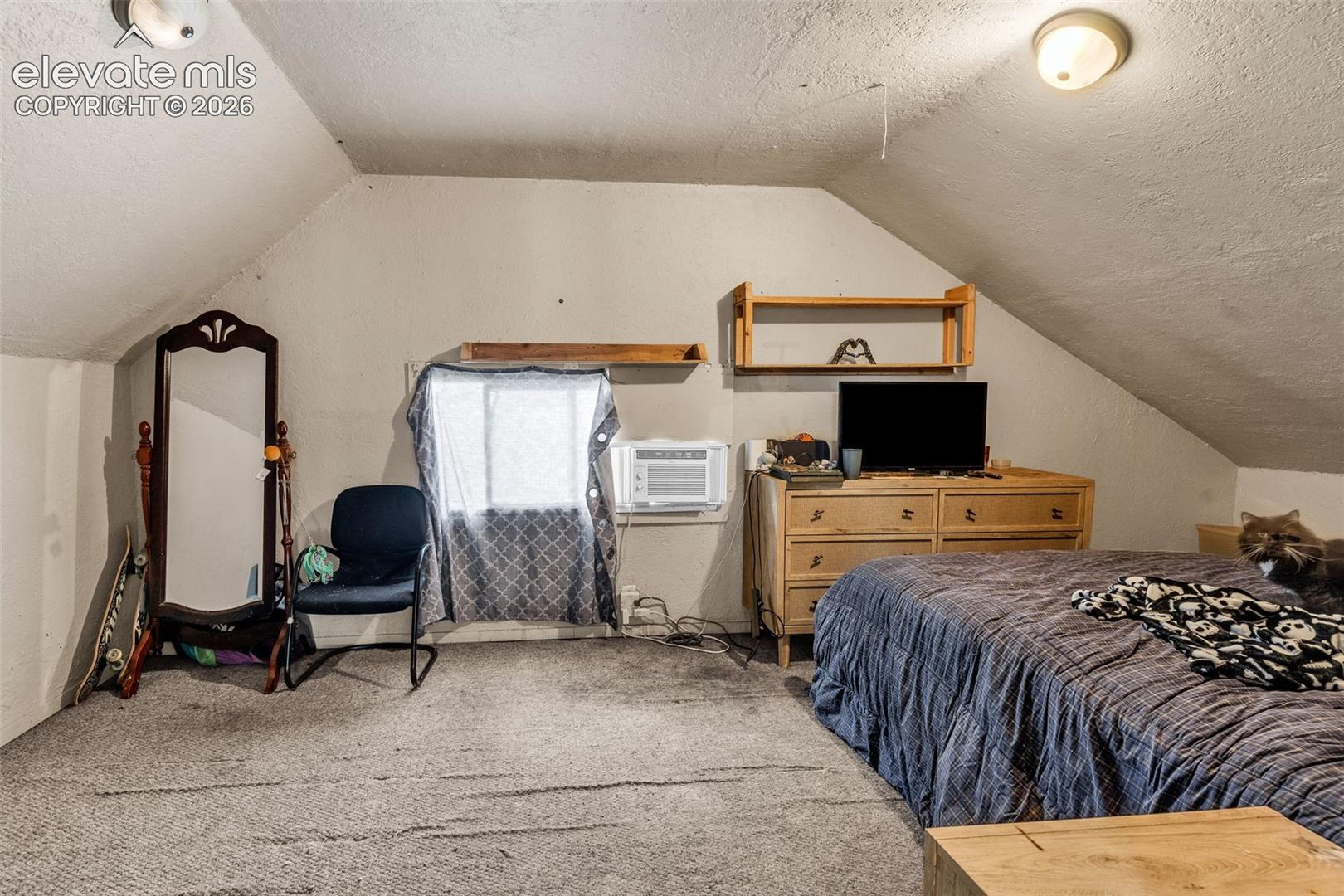 Sloped ceilings with recessed lighting, light-colored wall paint, and wall-to-wall carpeting