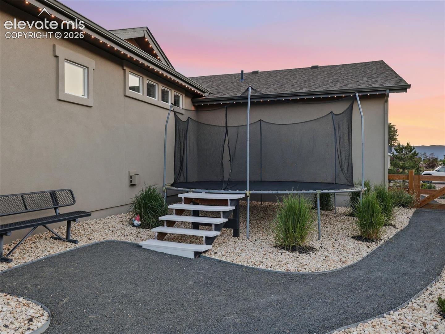 A LITTLE HIDDEN FUN — Perfectly positioned away from the main entertaining areas, this tucked-away trampoline offers a dedicated space for play without taking away from the beauty of the backyard.