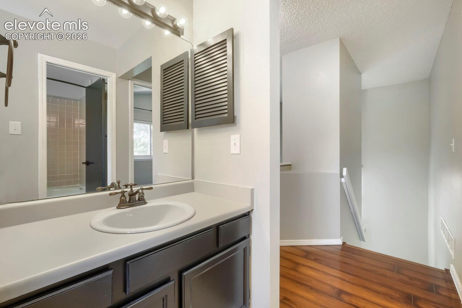 Bathroom vanity featuring a single basin sink, dual-handle faucet, and integrated countertop