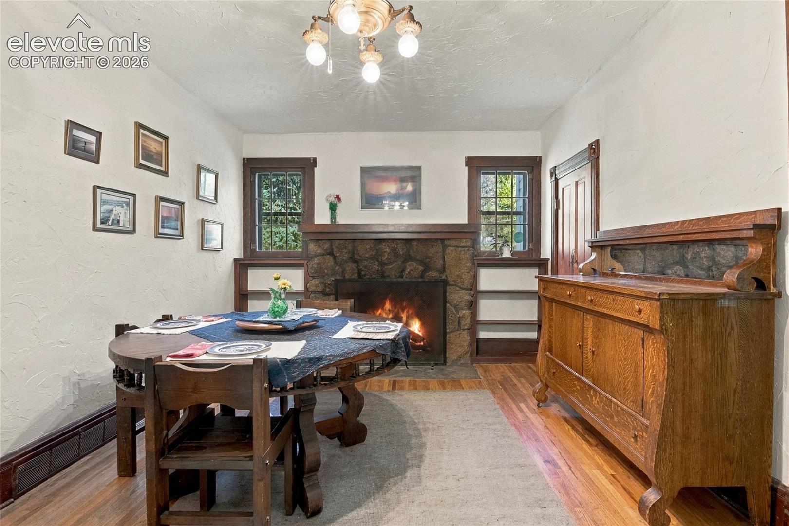 Other view of the dining room with two more windows and large stone fireplace