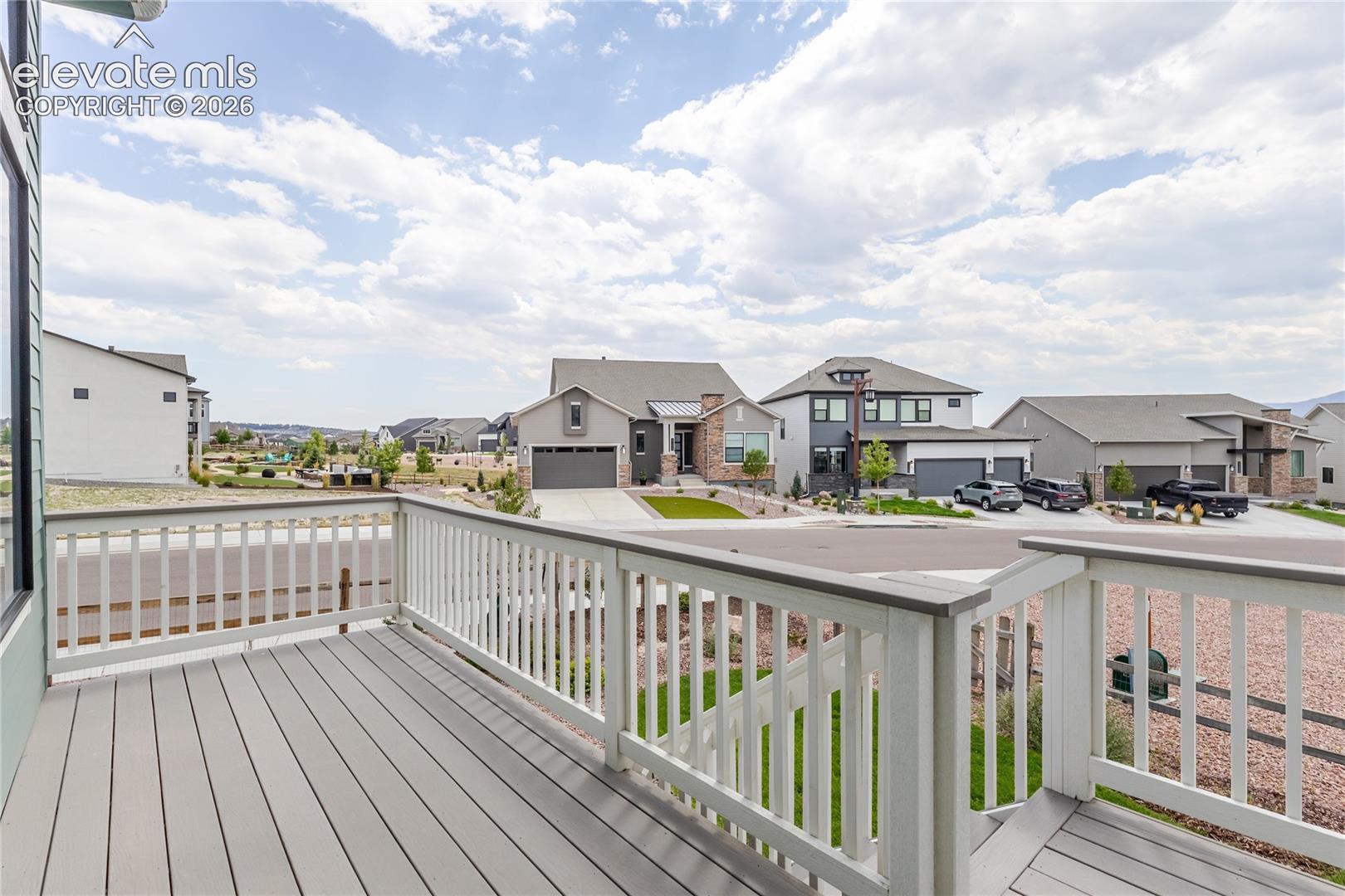 Expansive outdoor decking with composite planks, a white railing system, and a dark gray top rail