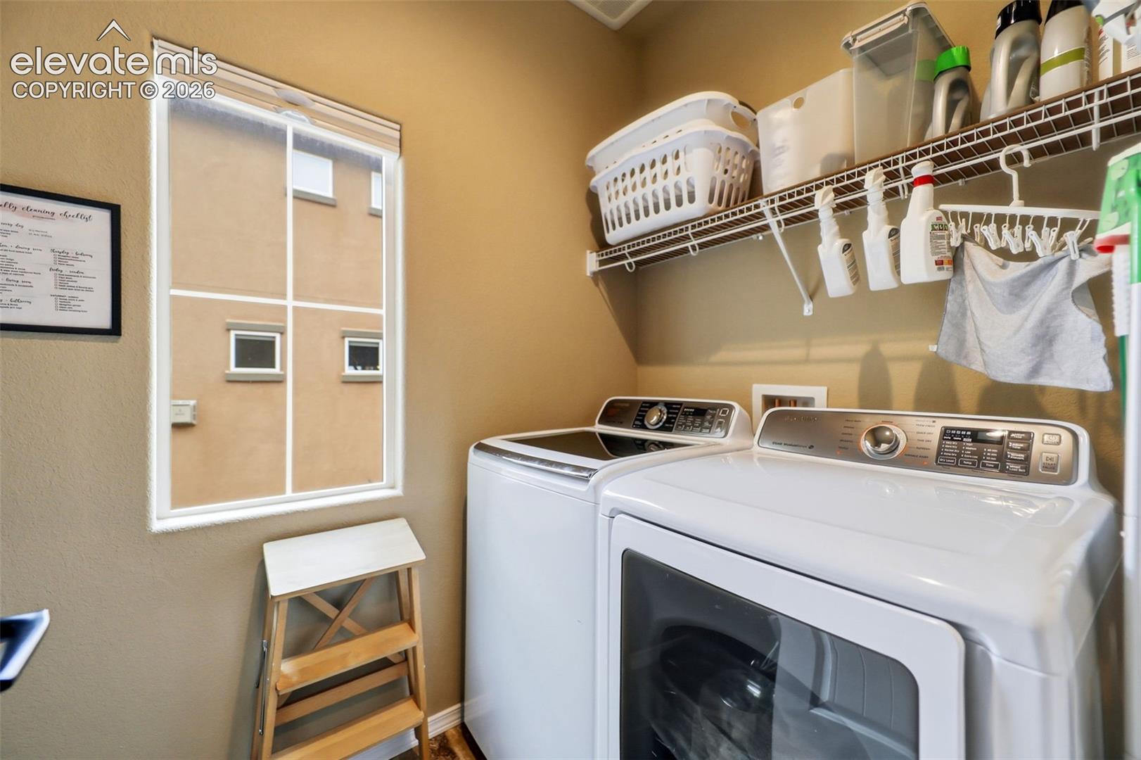 Dedicated laundry area featuring a window, built-in wire shelving, and neutral wall paint