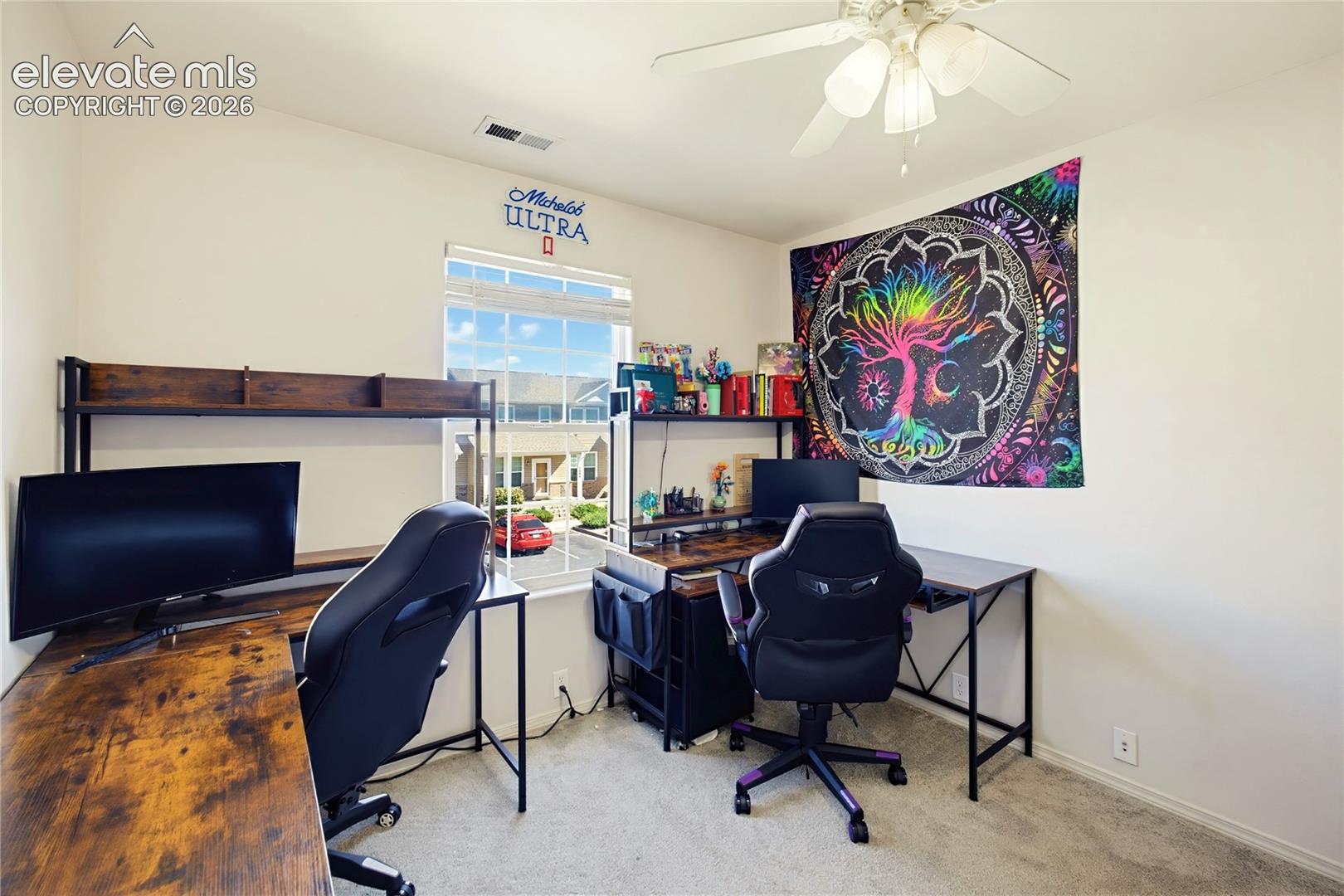 Carpeted flooring, ceiling fan, window with blinds, and built-in shelving