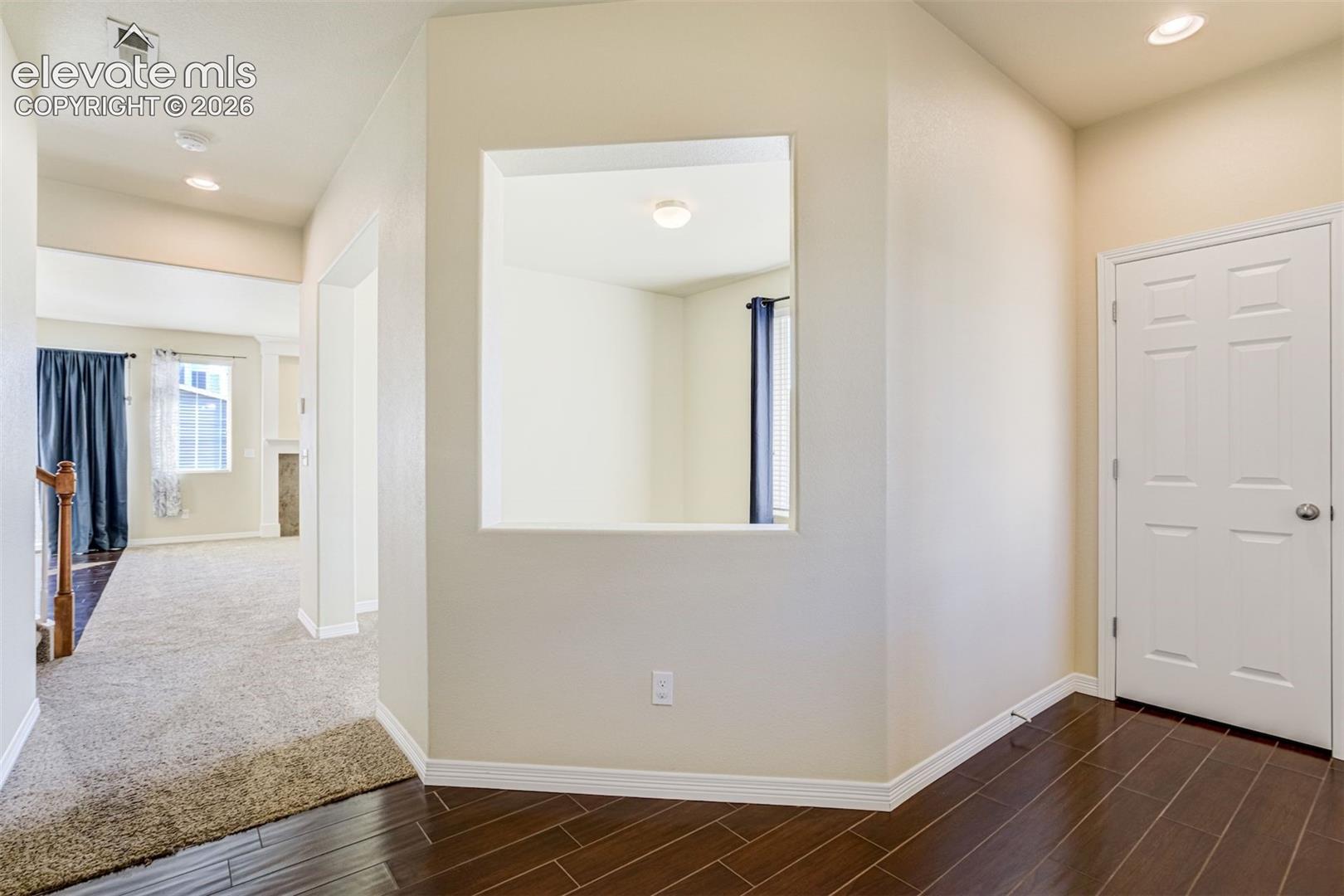 Tiled flooring, interior wall cut-out, recessed lighting, and a paneled interior door