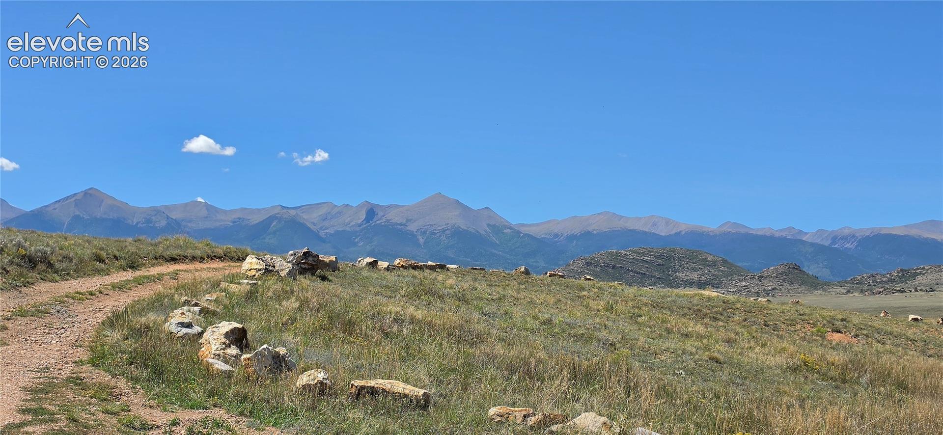 Mountain range backdrop, open terrain, natural rock formations, and clear sky