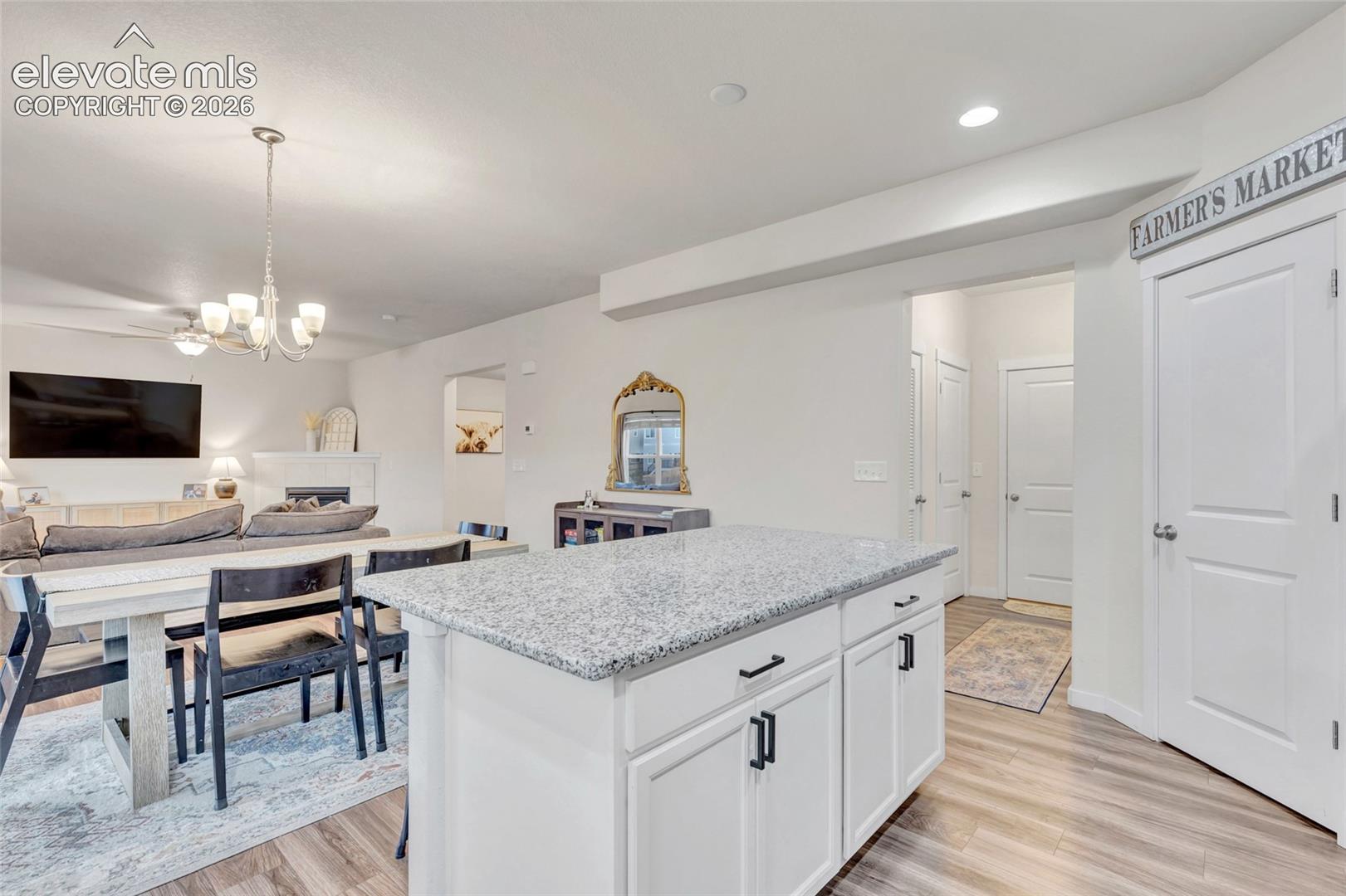 Kitchen island with light-toned granite countertop and white cabinetry