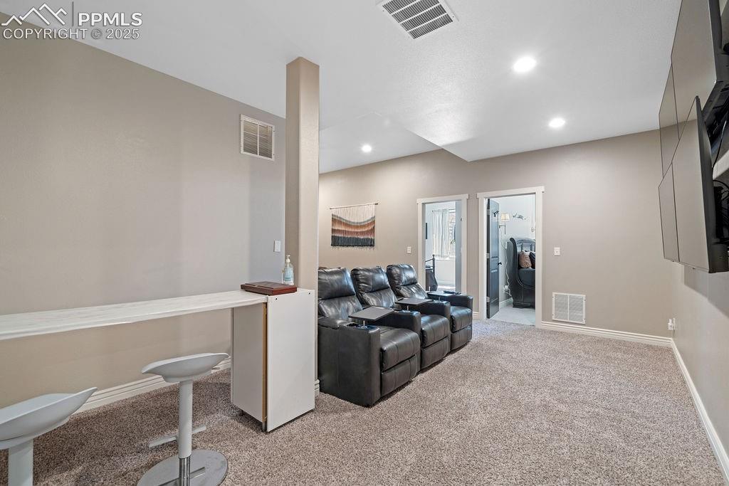 Living area with light colored carpet and recessed lighting