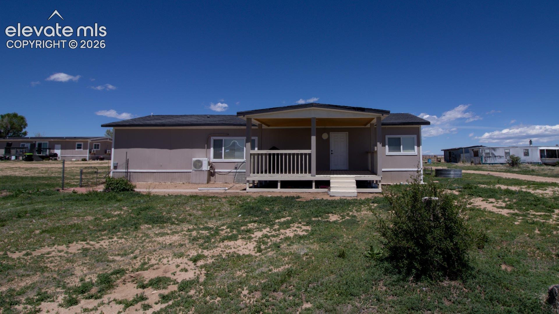  Back of house with a lawn and a cooling unit