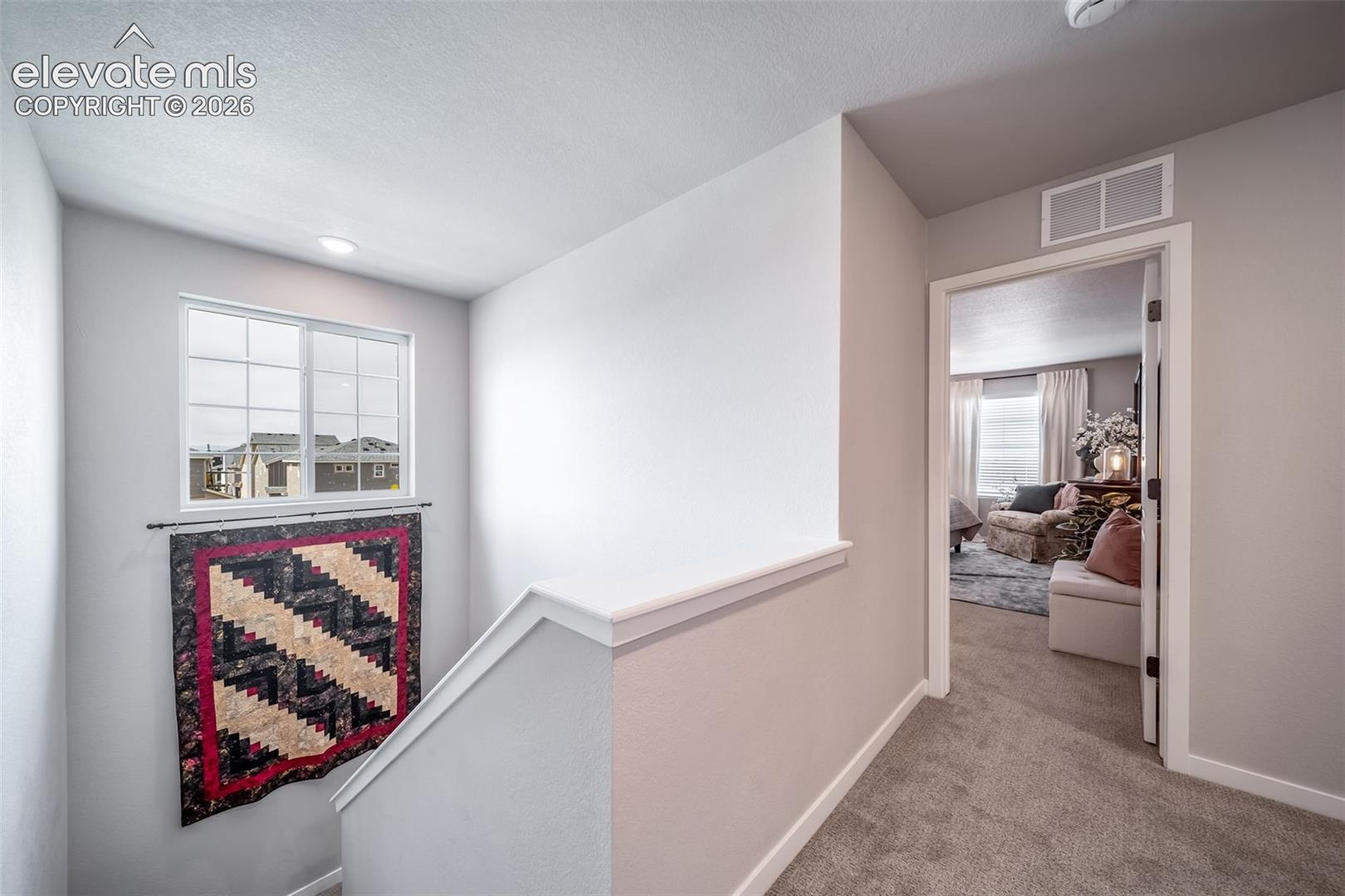 Upper-level hallway with neutral wall finishes and carpeted flooring
*Photos of a model home*
