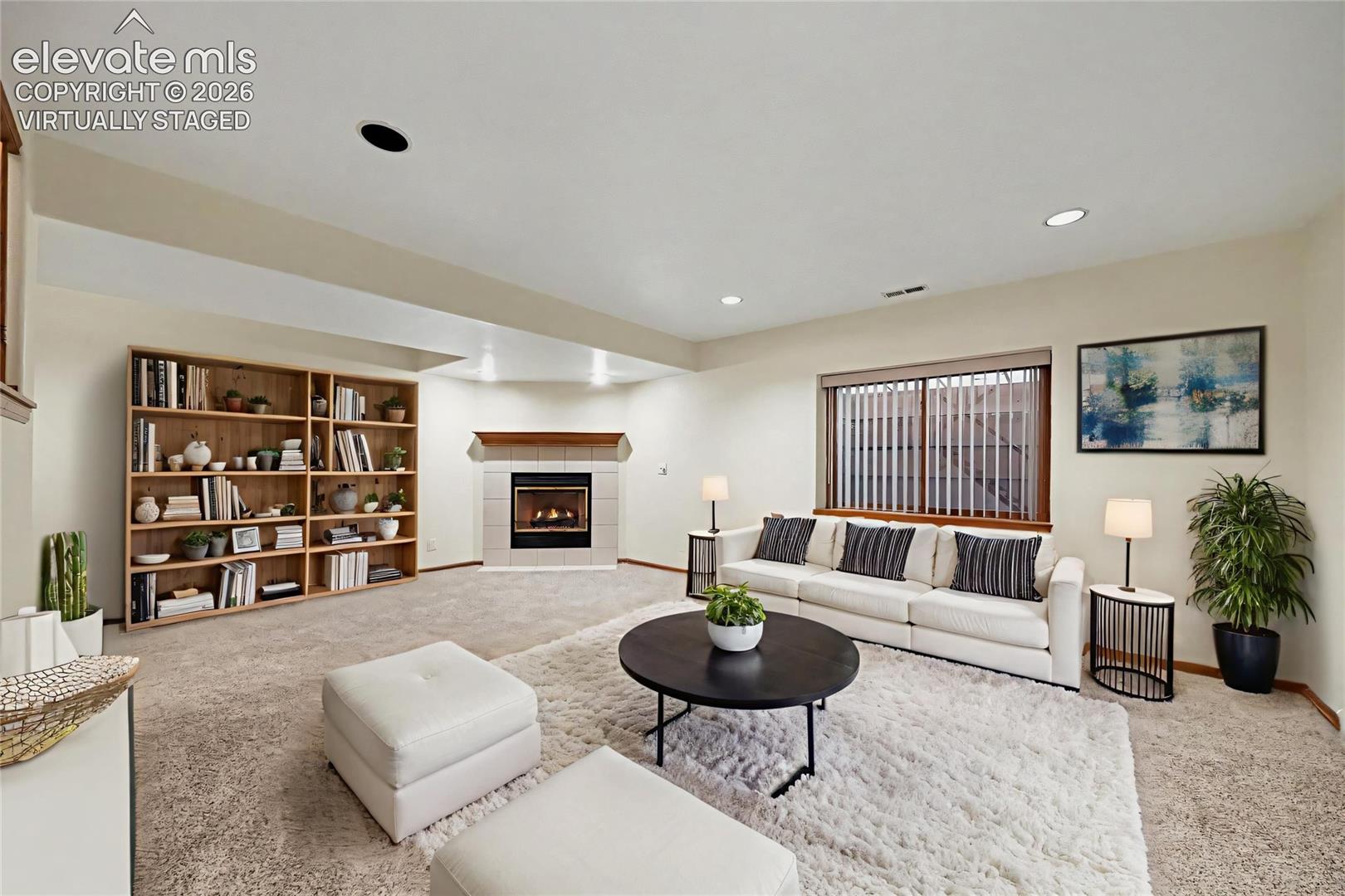 virtually staged Recessed lighting, wood-finish window trim, and a built-in corner fireplace with a tile surround