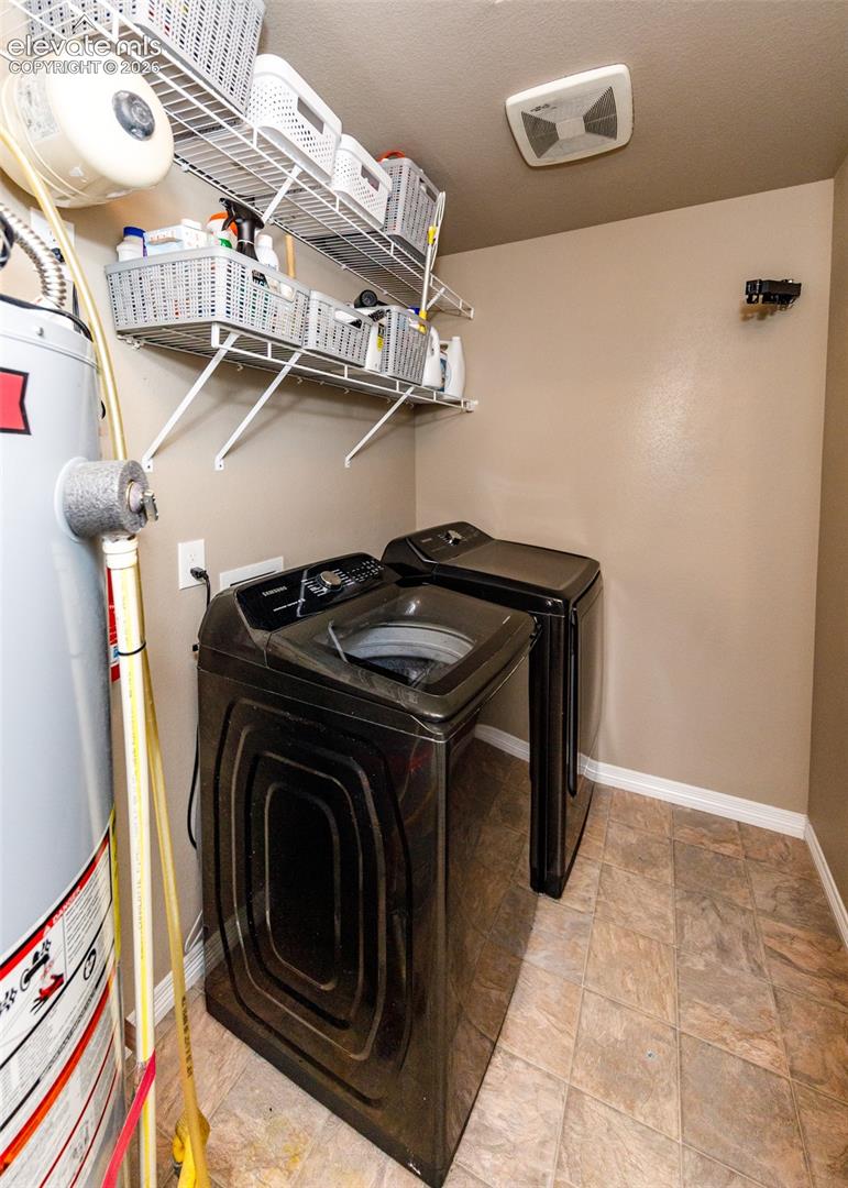 Utility space featuring vinyl tile flooring, dual-tier wire shelving, and a ceiling-mounted exhaust fan