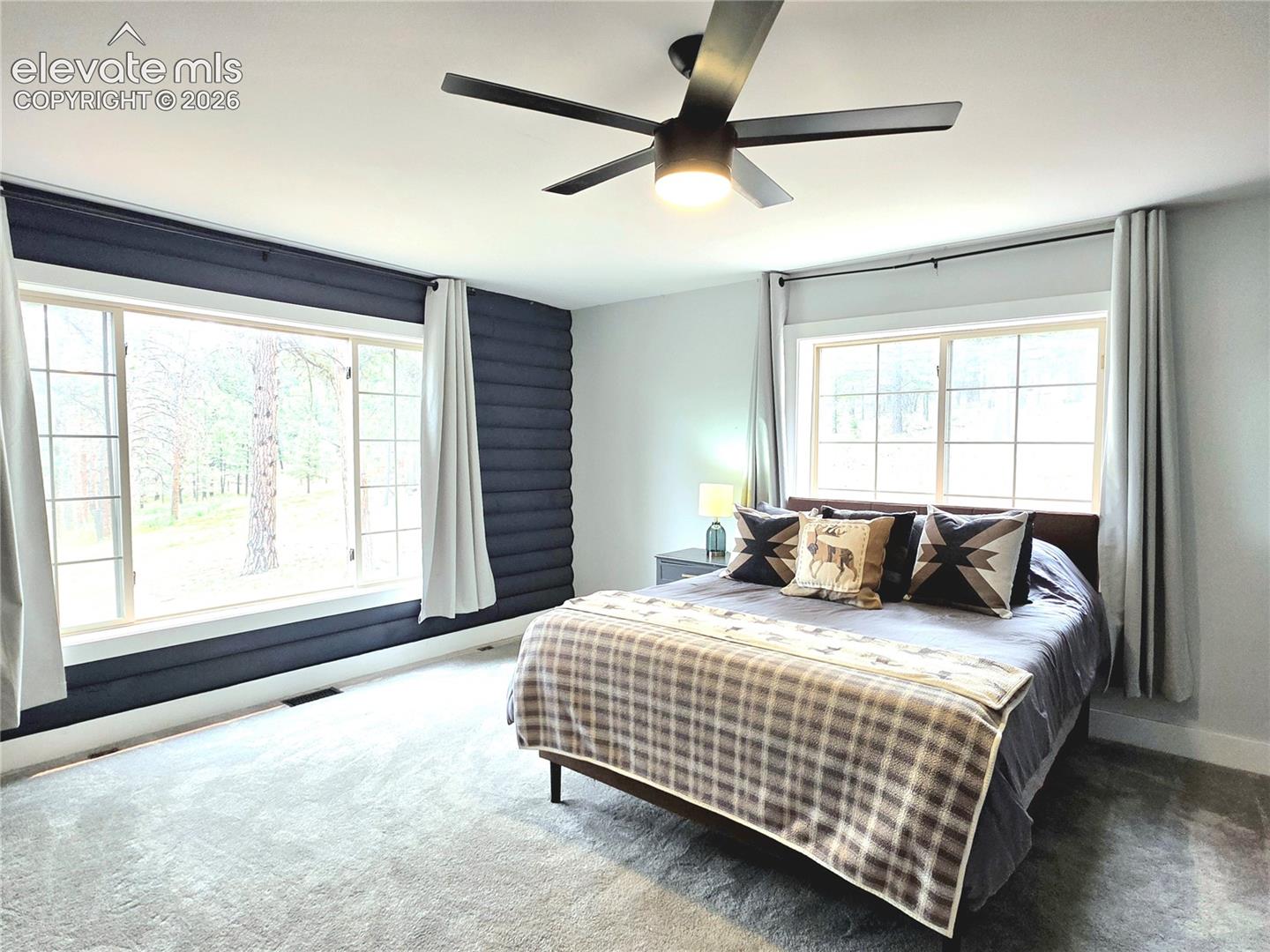 secondary main level bedroom is spacious and has wonderful views to the front of the home