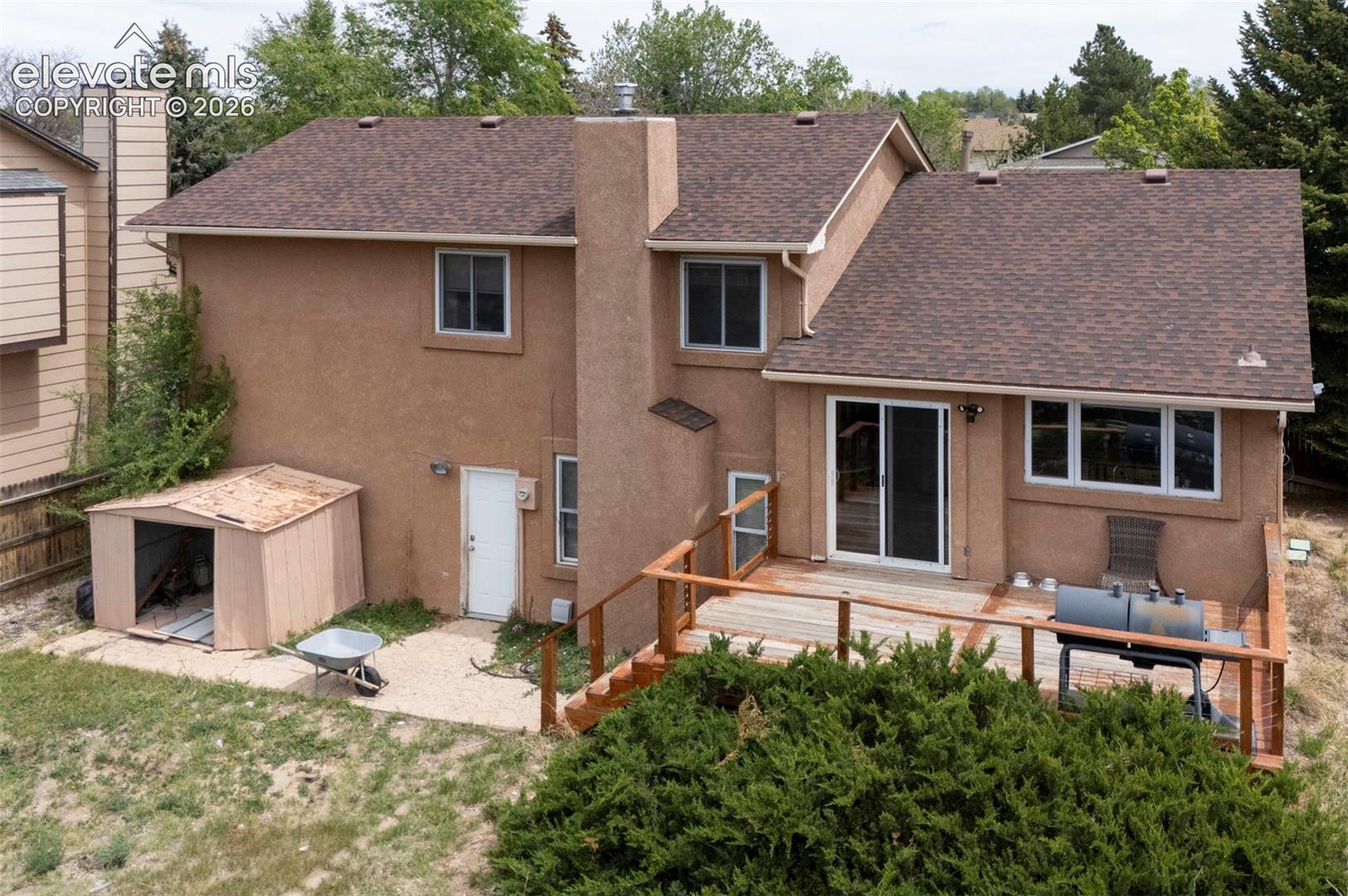 Stucco exterior residence with a multi-level composite shingle roof