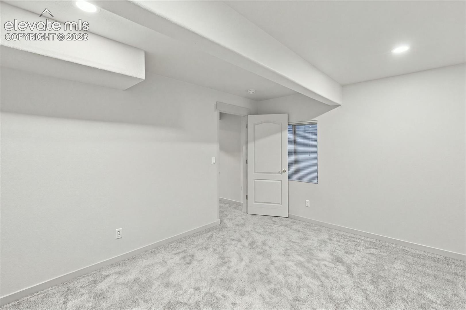 Neutral interior featuring wall-to-wall carpeting, recessed ceiling lighting, and a single-panel interior door