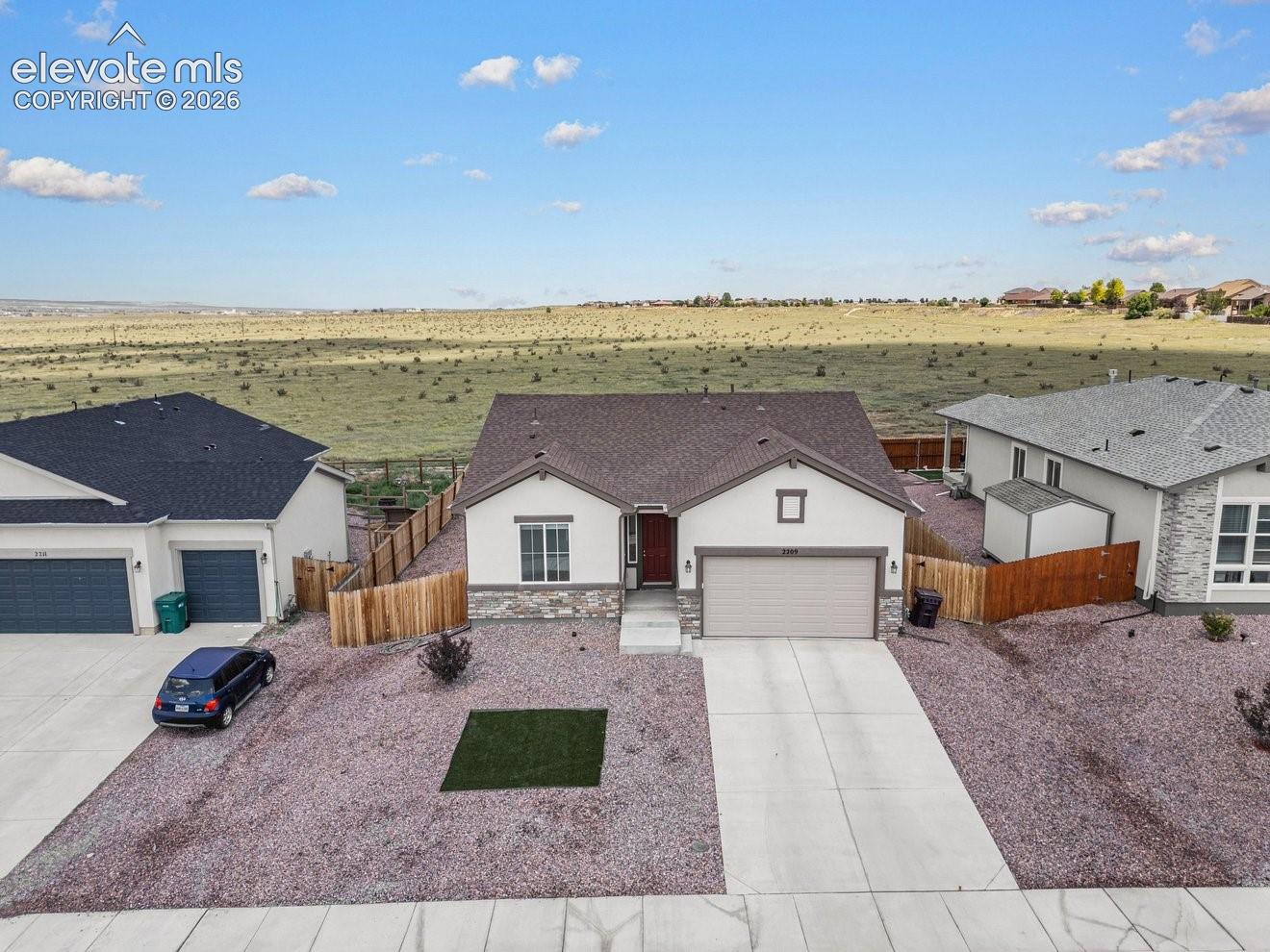 Charming single-story home featuring a clean stucco exterior with a dark asphalt shingle roof, two-car attached garage, and a front-facing driveway