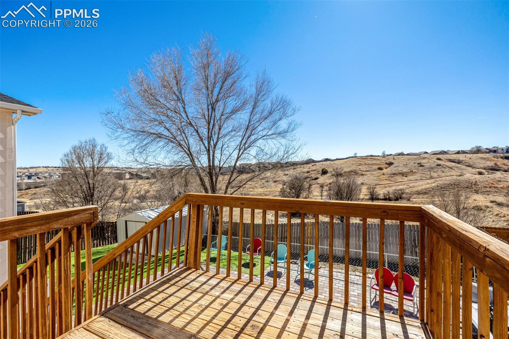 Deck overlooking backyard and open space with trails