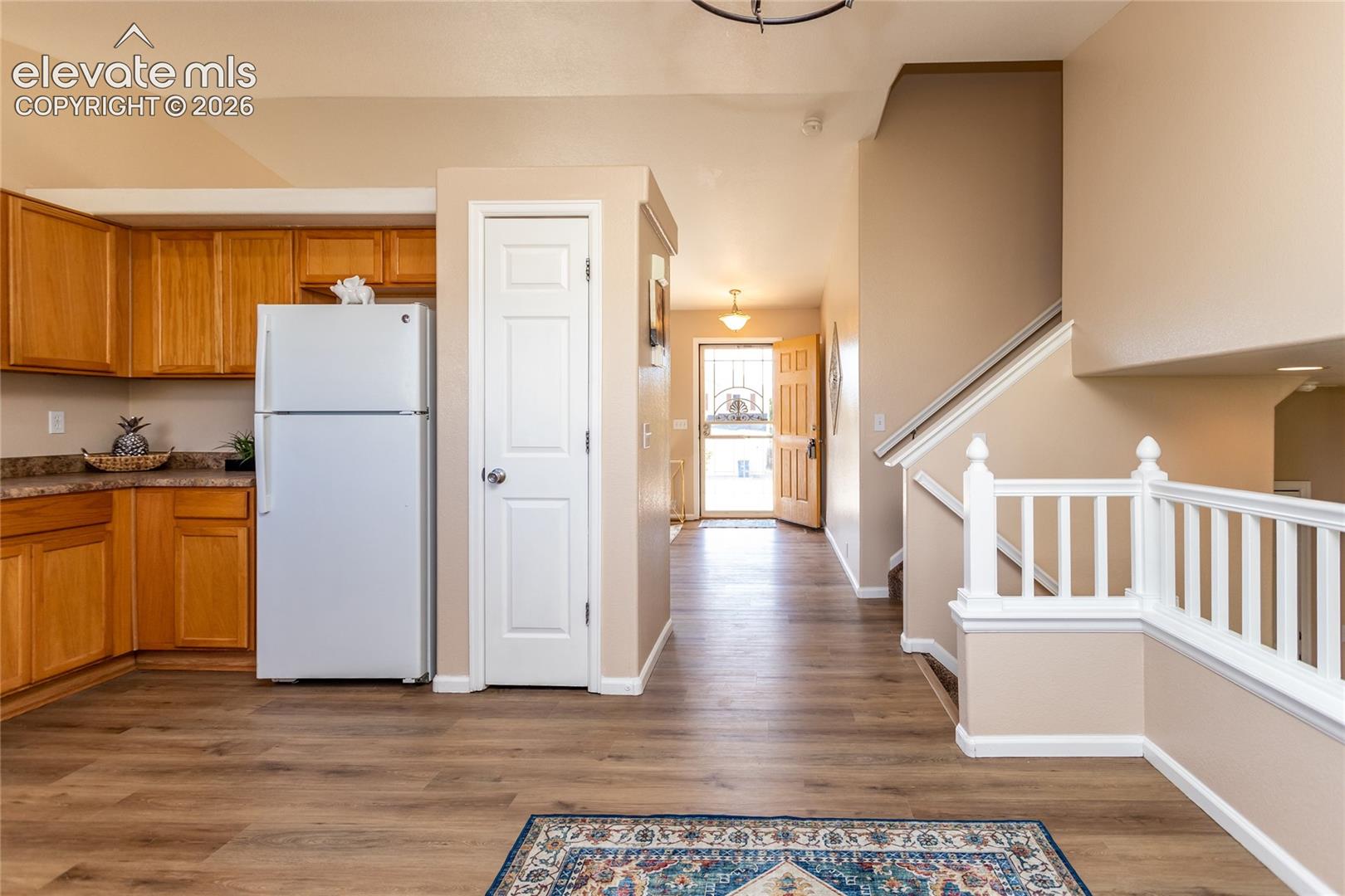 The functional central hub connects the kitchen, dining nook, entry foyer, and upper bedroom levels effortlessly
