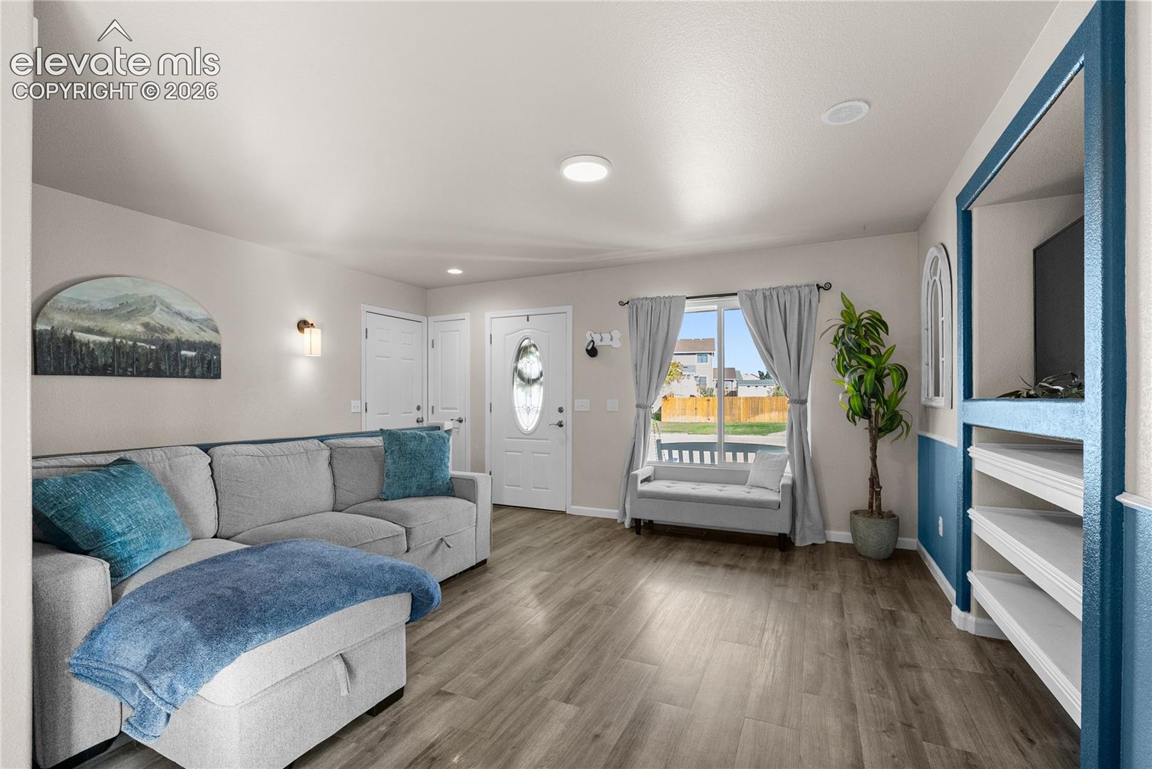 Wood-finish flooring, recessed lighting, and a built-in media center with shelving