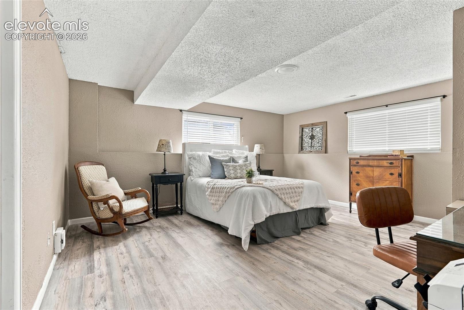 Room featuring light wood-finish flooring, neutral wall tones, and a textured ceiling