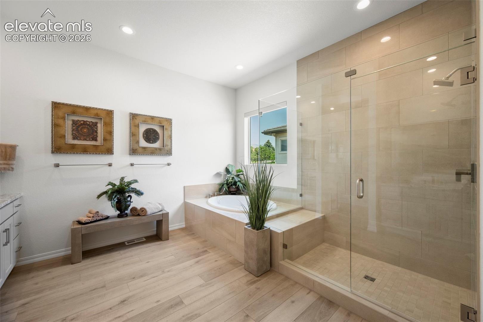 Walk-in shower with clear glass enclosure and tiled walls