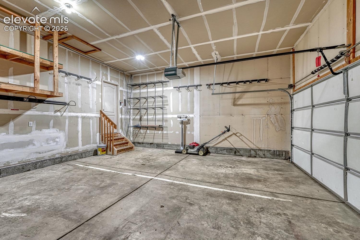 3-car attached garage with mounted tool rack and custom storage that stays.