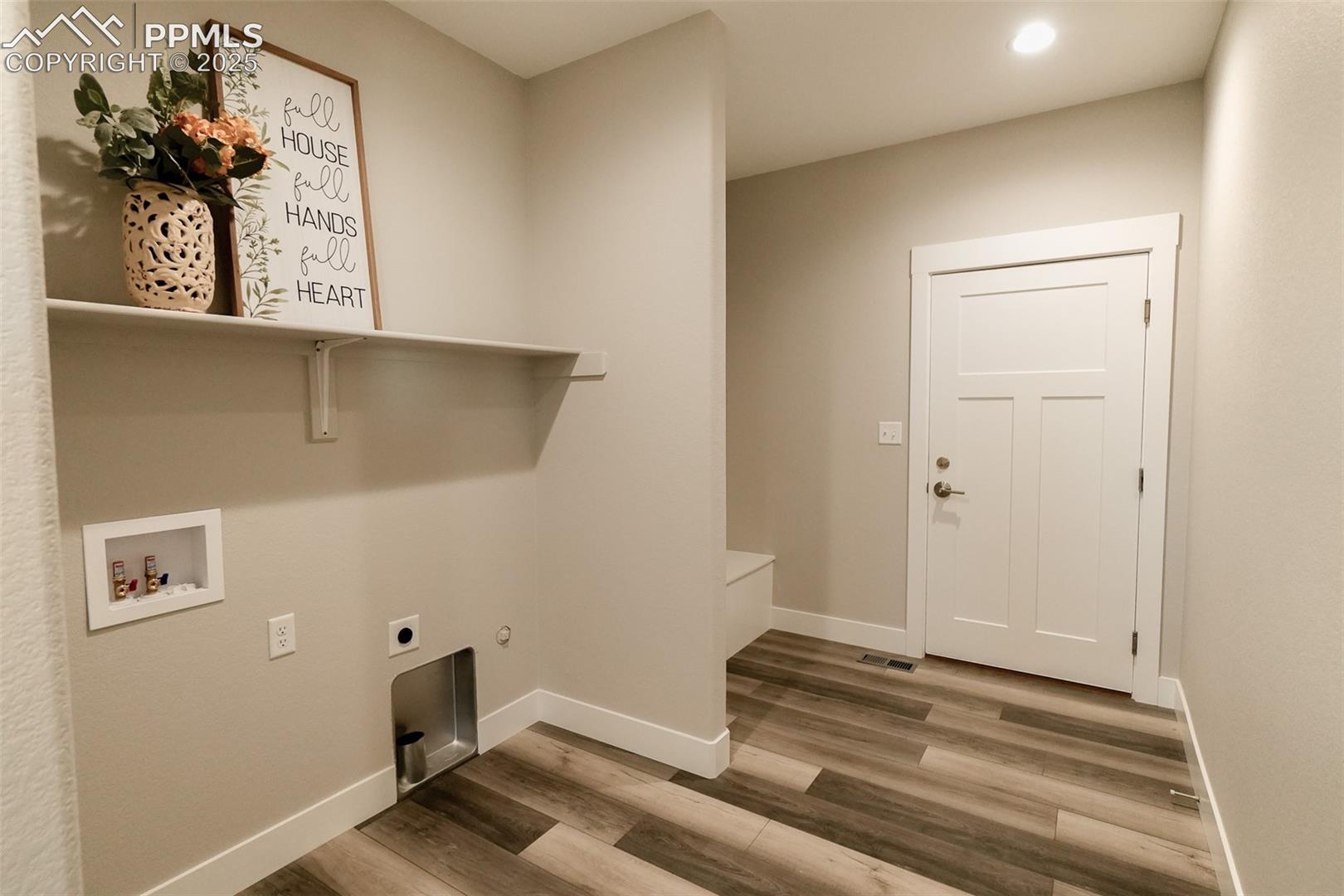 Clothes washing area featuring hookup for an electric dryer, LTV/ wood-style floors, and washer hookup