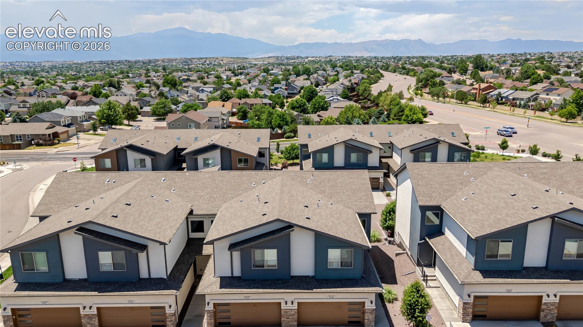 Modern townhome complex featuring multi-toned siding, attached garages, and a distinctive roofline