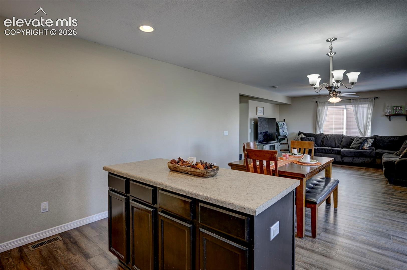 Kitchen island with ample cabinetry, light-toned countertop, and recessed lighting