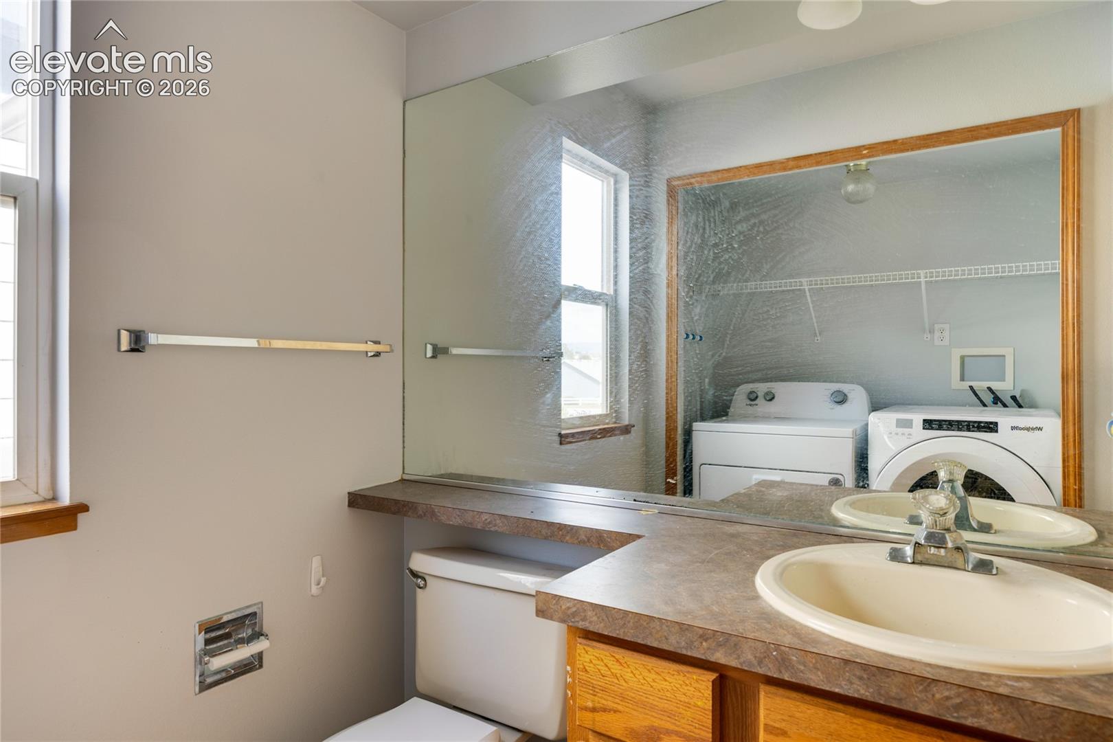 Vanity with an integrated sink, built-in cabinetry, and a full-width mirror
