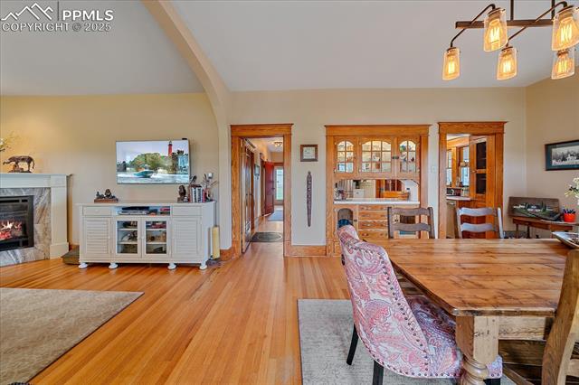 Dining area with wood finished floors and a high end fireplace