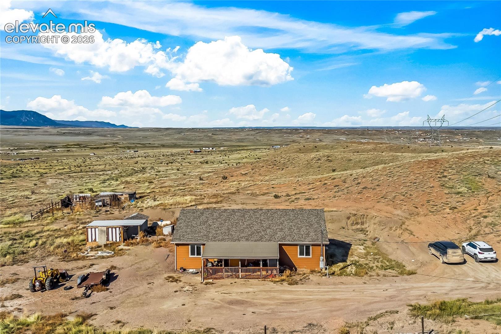 Single-story residence featuring a shingle roof, a covered front porch, and expansive mountain scenery