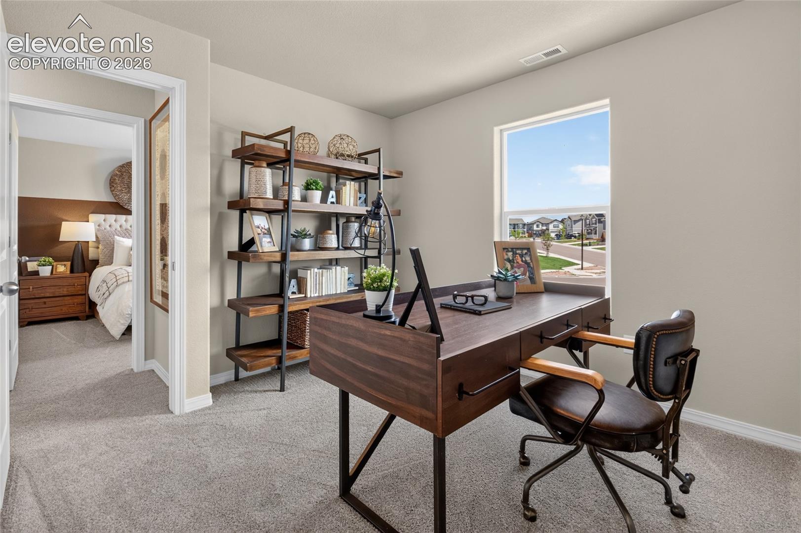 Neutral-toned room featuring wall-to-wall carpeting and a single-pane window