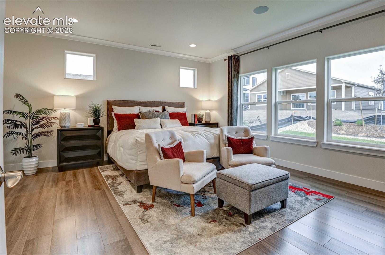 Wood-finish flooring, recessed lighting, multiple windows, built-in ceiling speaker, and crown molding
