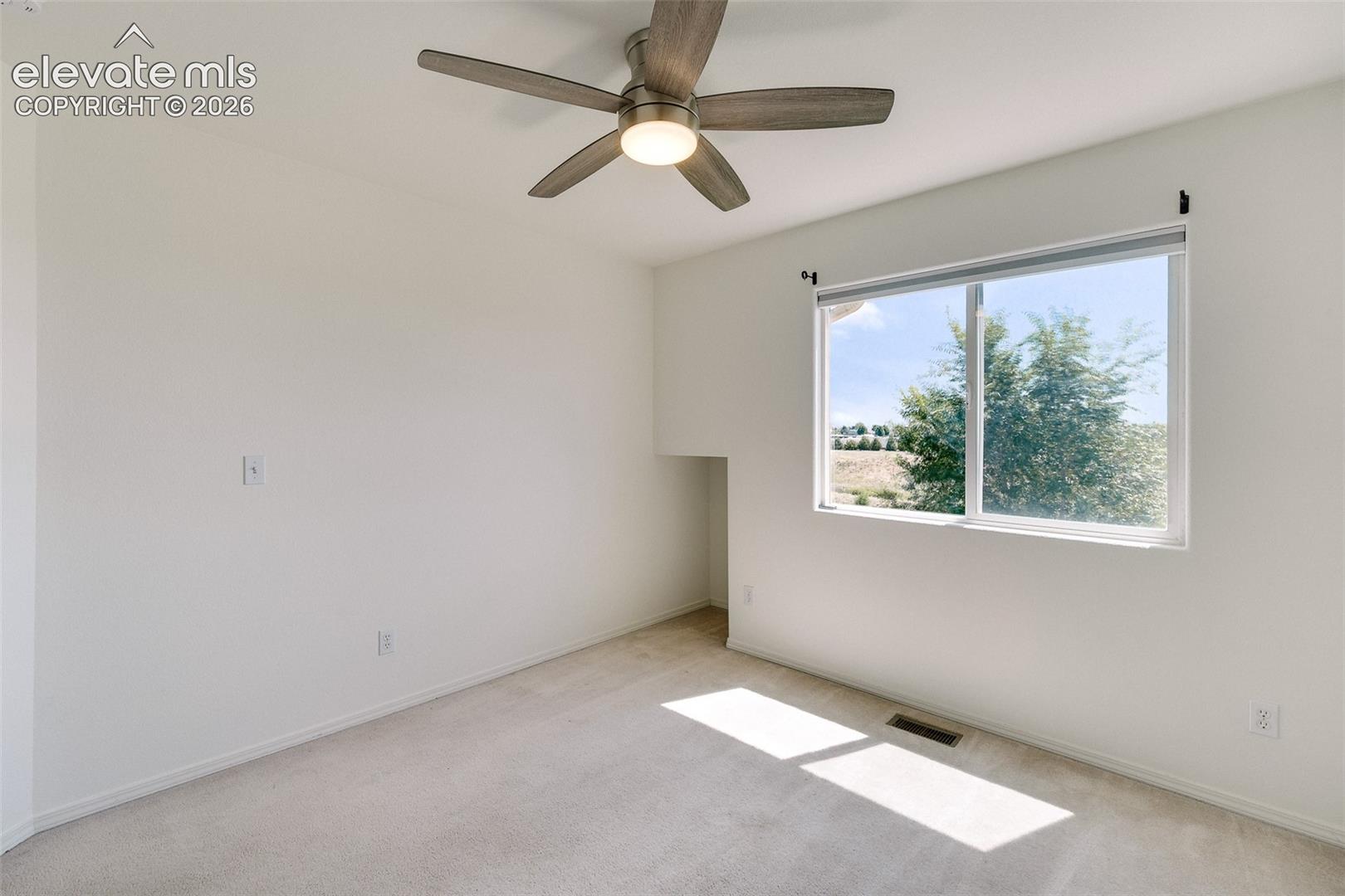 Recessed window, ceiling fan with integrated lighting, and neutral carpeting