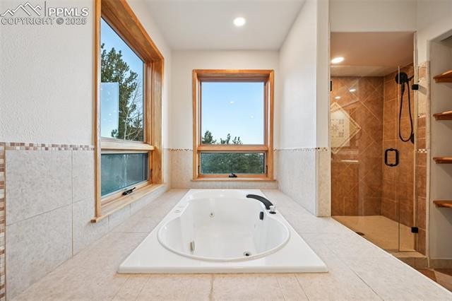 Primary bathroom highlighting the jetted tub with private mountain views out of the windows