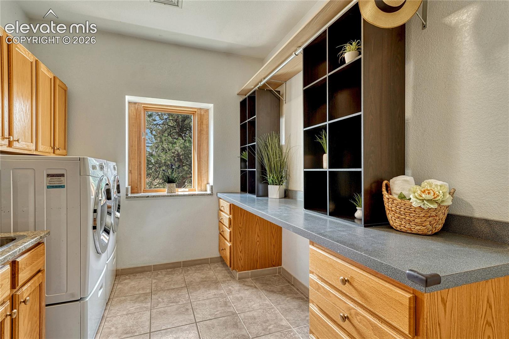 Laundry has built-in cabinets and a long folding counter.
