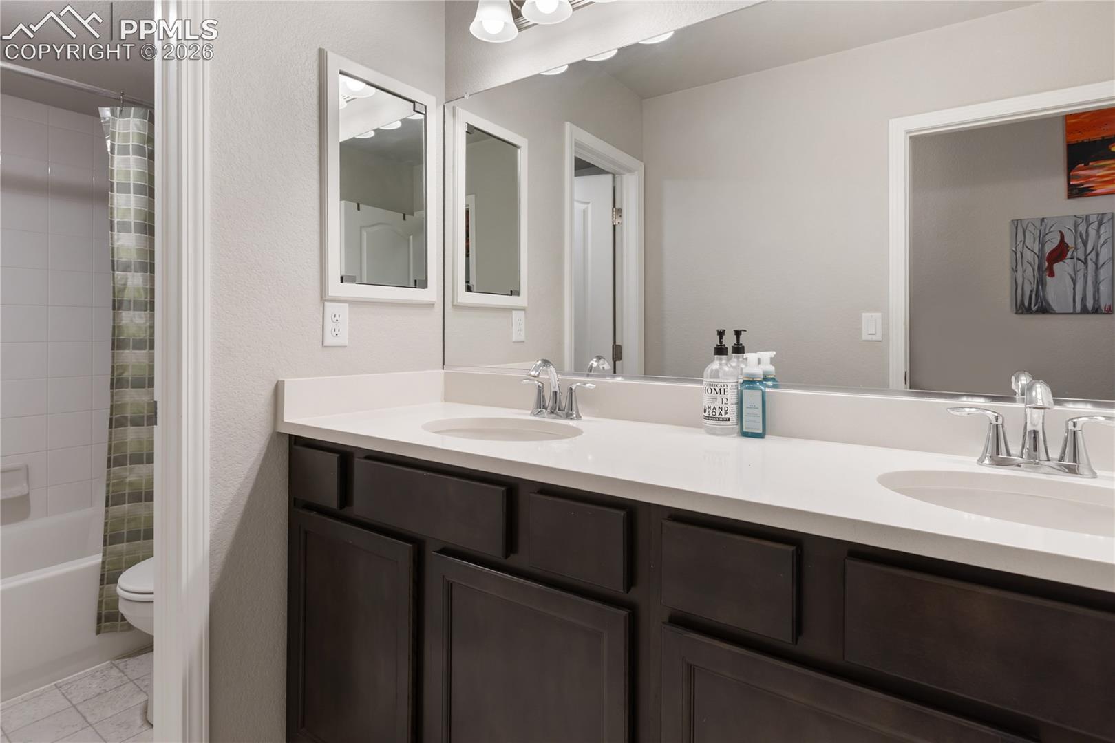 Convenient laundry room with upper cabinetry and utility sink